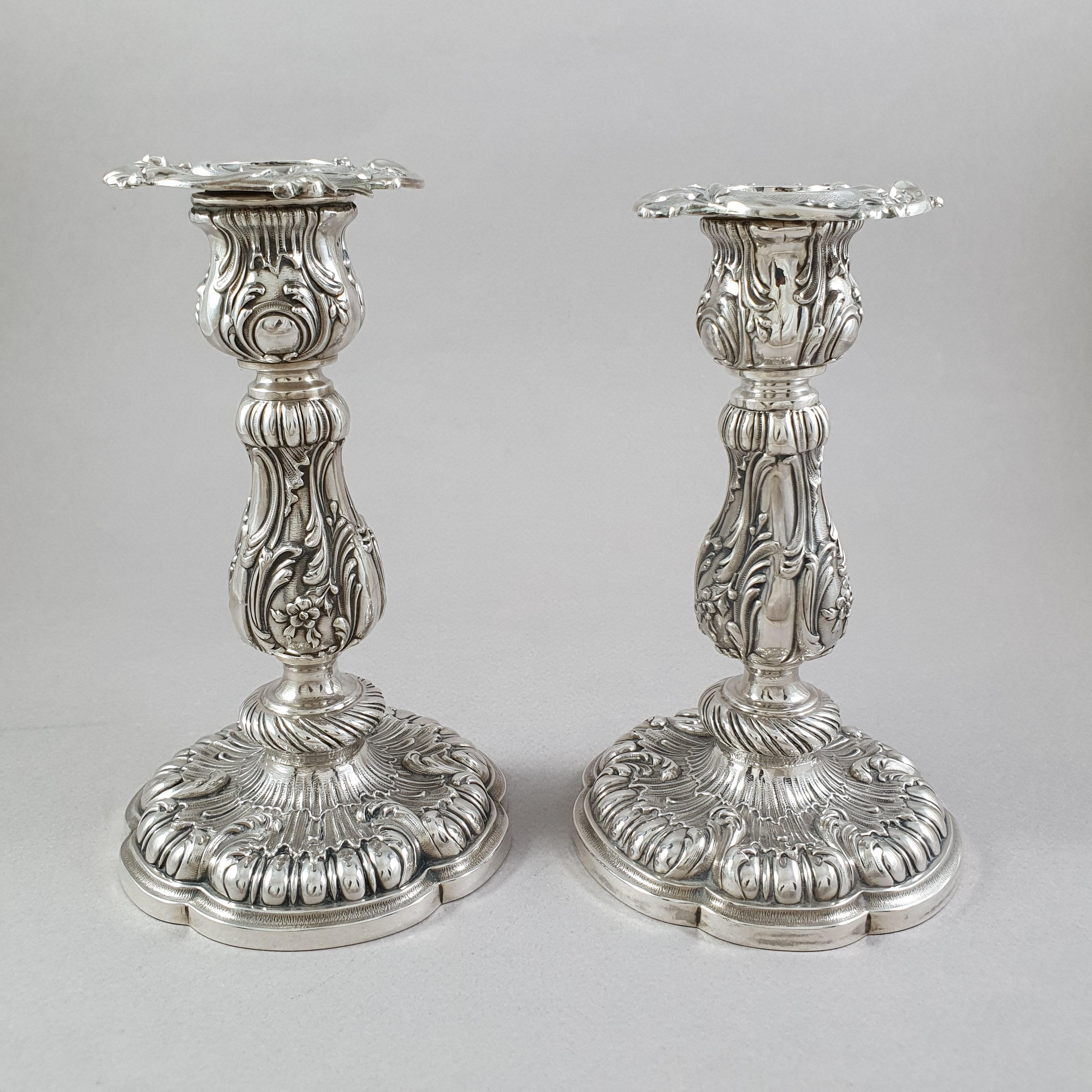 Pair of French Sterling Silver candlesticks from the 19th century 

Decorated with gadroons, rocailles patterns, foliage and flowers. 

French Sterling silver hallmark boar head 
Silversmith: Léon Gariod 
Height: 13.5 cm 
Weight: 445