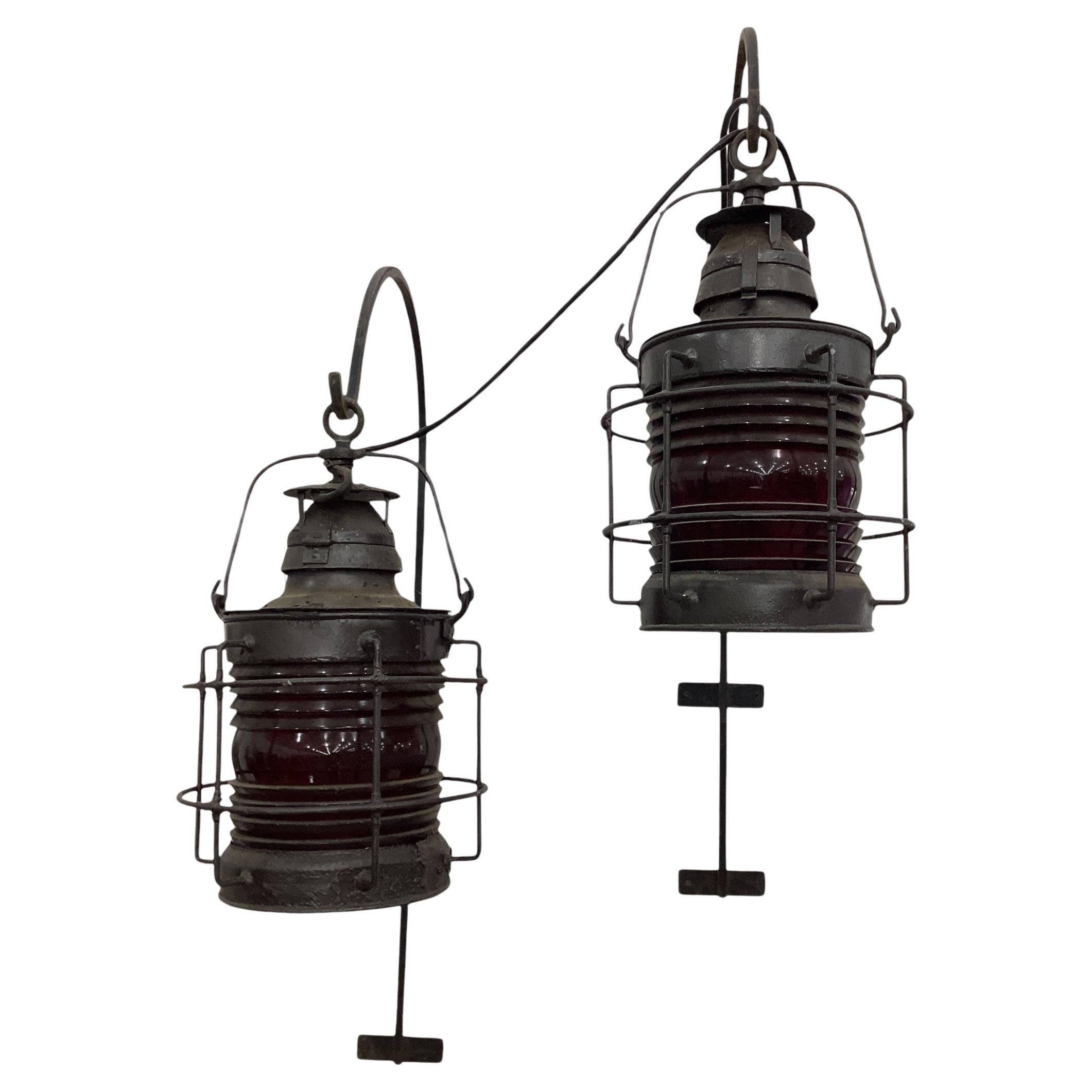 A pair of Nautical Ships Lantern with red glass lens and electrified. Lanterns are in good condition with signs of outdoor use, some paint loss and chipping paint that has been painted over.