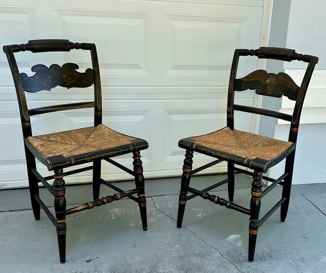 Pair of 2 Hitchcock Black Federal Side Chairs, Rush Seats.

These vintage Hitchcock chairs are black lacquer painted and embellished with ochre banding and gold stencil work.  One slatback chair is decorated with a harvest design, the other chair