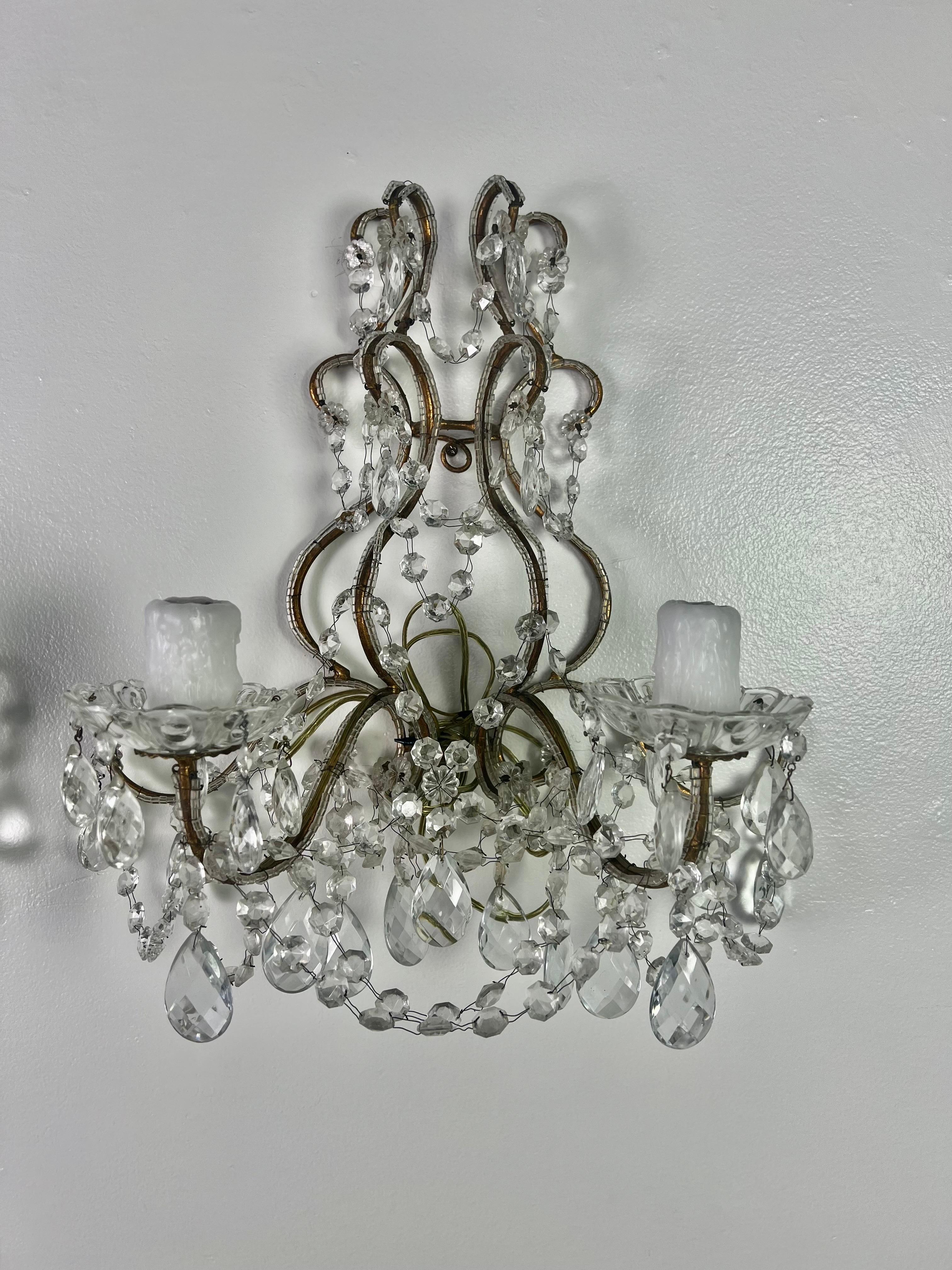Pair of French 2-light crystal beaded sconces. The sconces are adorned with faceted almond shaped crystals and garlands of English cut beads. The sconces are newly rewired with drip wax candle covers. There are four sconces available.