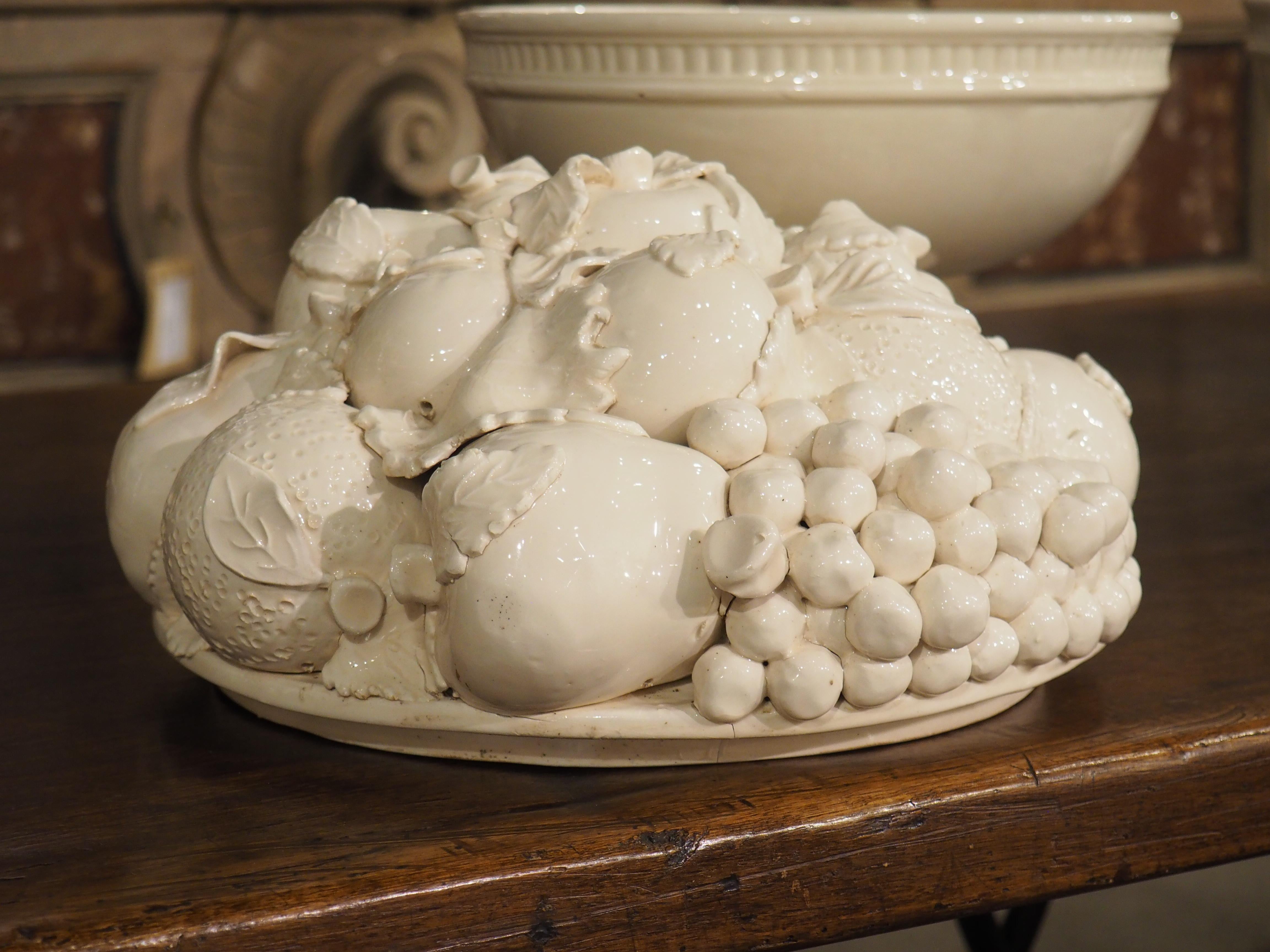 The realism of this pair of two-piece creamware fruit bowls from Italy (dating to the 1900s) is quite impressive. Both lids are depicted as overflowing arrangements of fruit featuring bananas, pomegranates, pears, grapes, and more. Some of the fruit