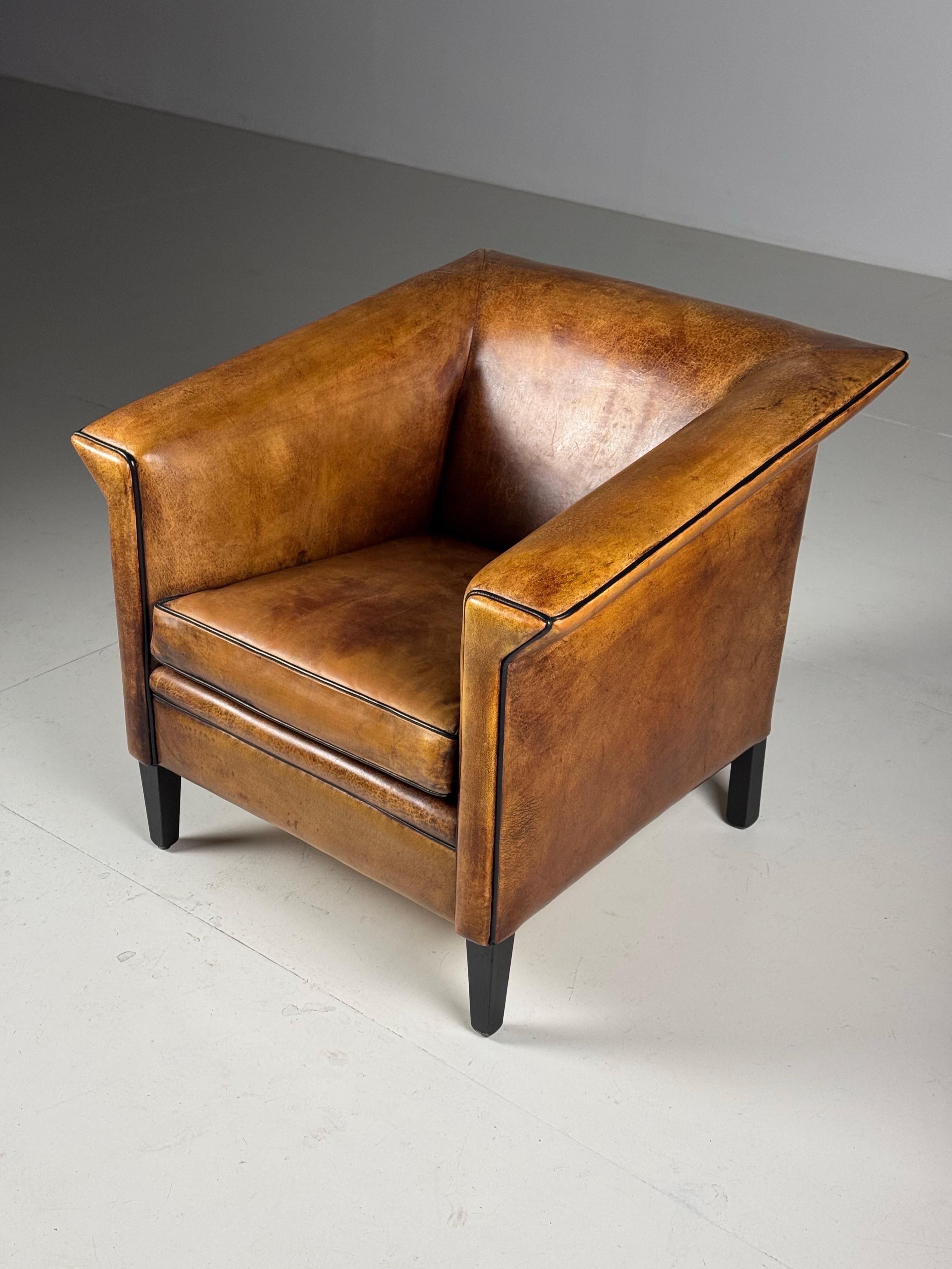 Set of 2 sheepskin club chairs / armchairs. Made by Lounge Atelier. Inspired by Art Deco style. Fantastic color and patina, finished with black piping. Condition is very good.

Brand: Lounge Atelier
Model: Amsterdam