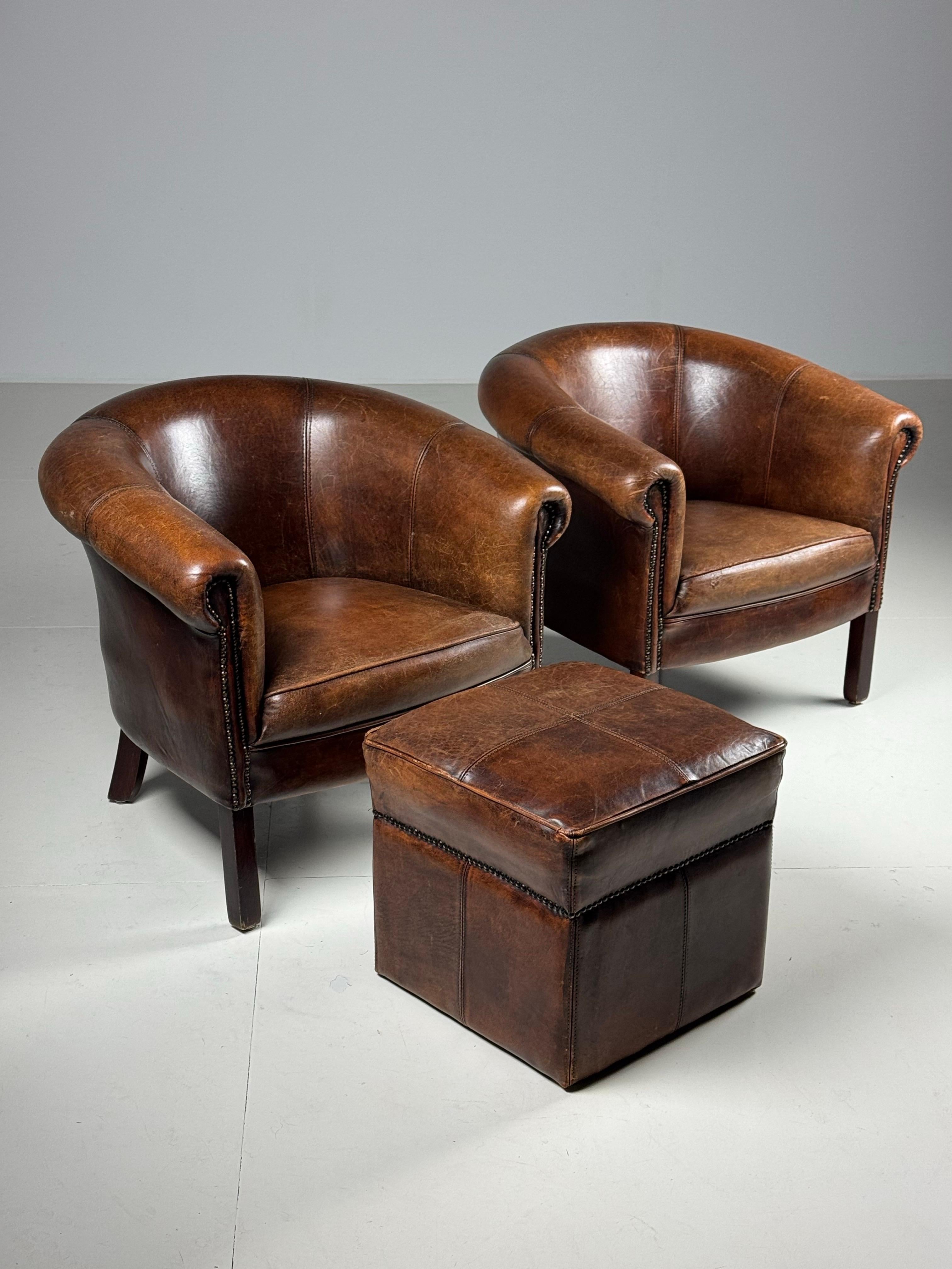 Set of 2 classic club chairs / armchairs. Upholstered in sheep leather. Slight signs of use consistent with age. One small damage on front seat (see photo). Beautiful colour and patina. With matching footstool.

Dimensions: W81 x D72 x H71