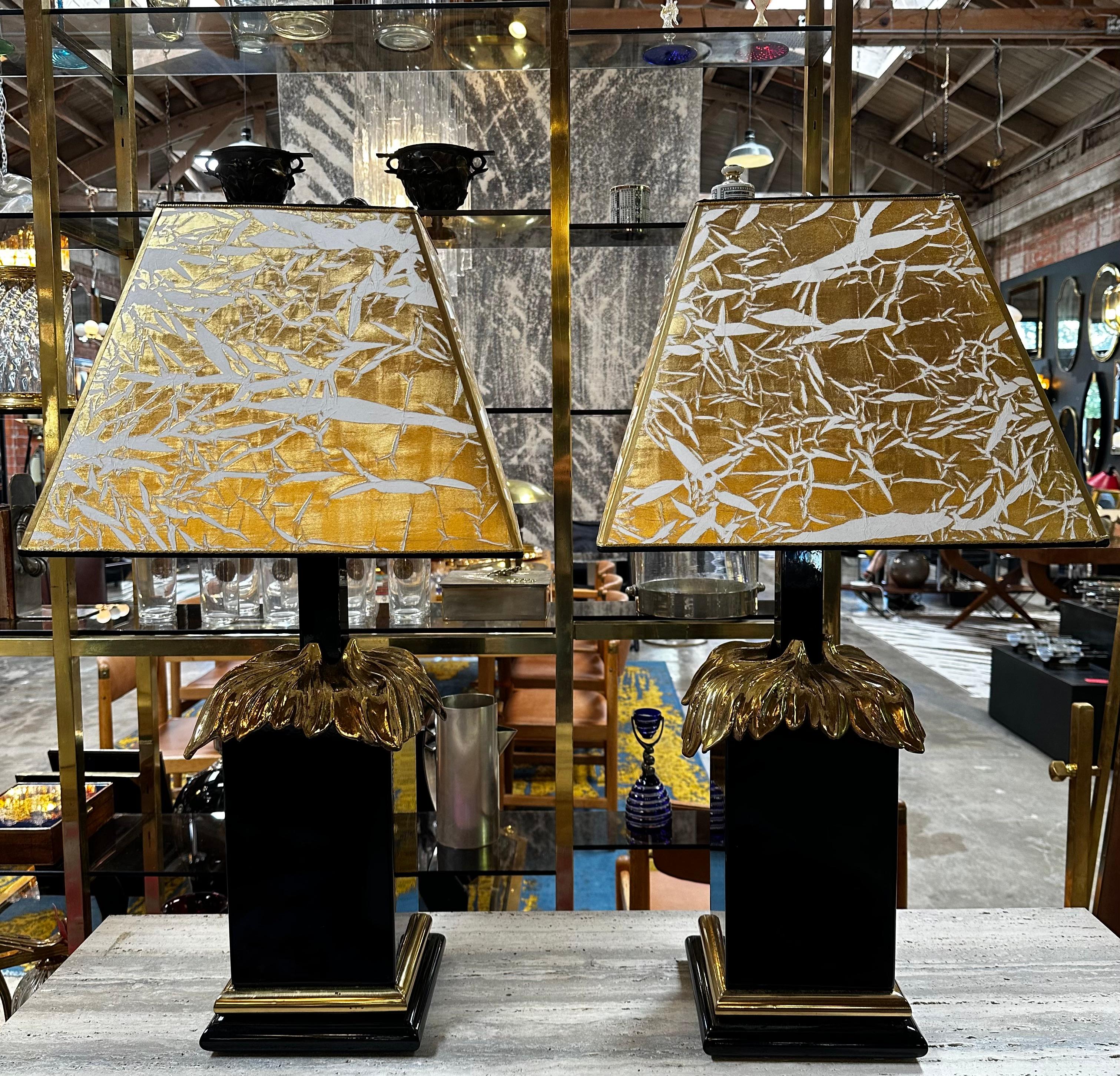 Extraordinary pair of 2 Art Deco Italian Table lamps made in Italy 1980s the lamps are in black with a brass metal on the top of the base with a white and gold shade.