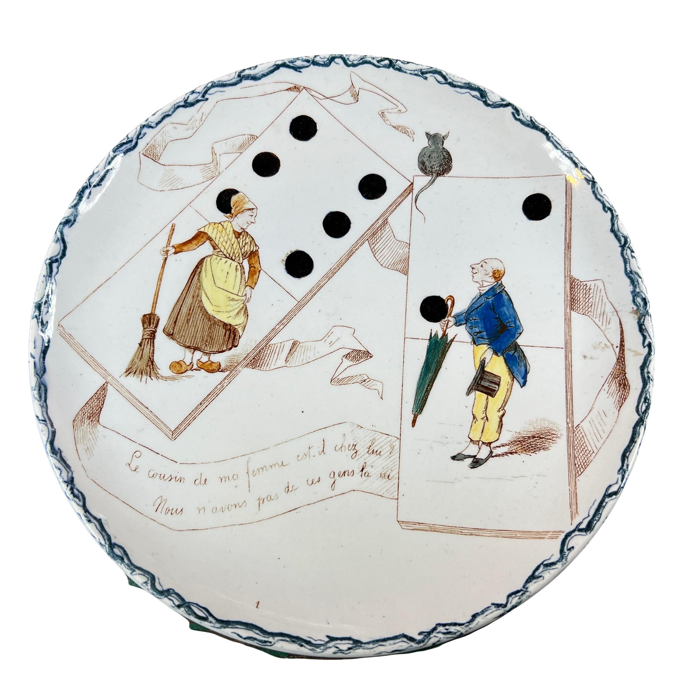 Ensemble de 2 assiettes humoristique sur le thème des jeux anciens, les dominos, par la manufacture française de Creil Montereau en 1890.

Sur l’assiette, nous voyons une femme en sabot, un balai à la main et sans l'autre un homme avec un parapluie
