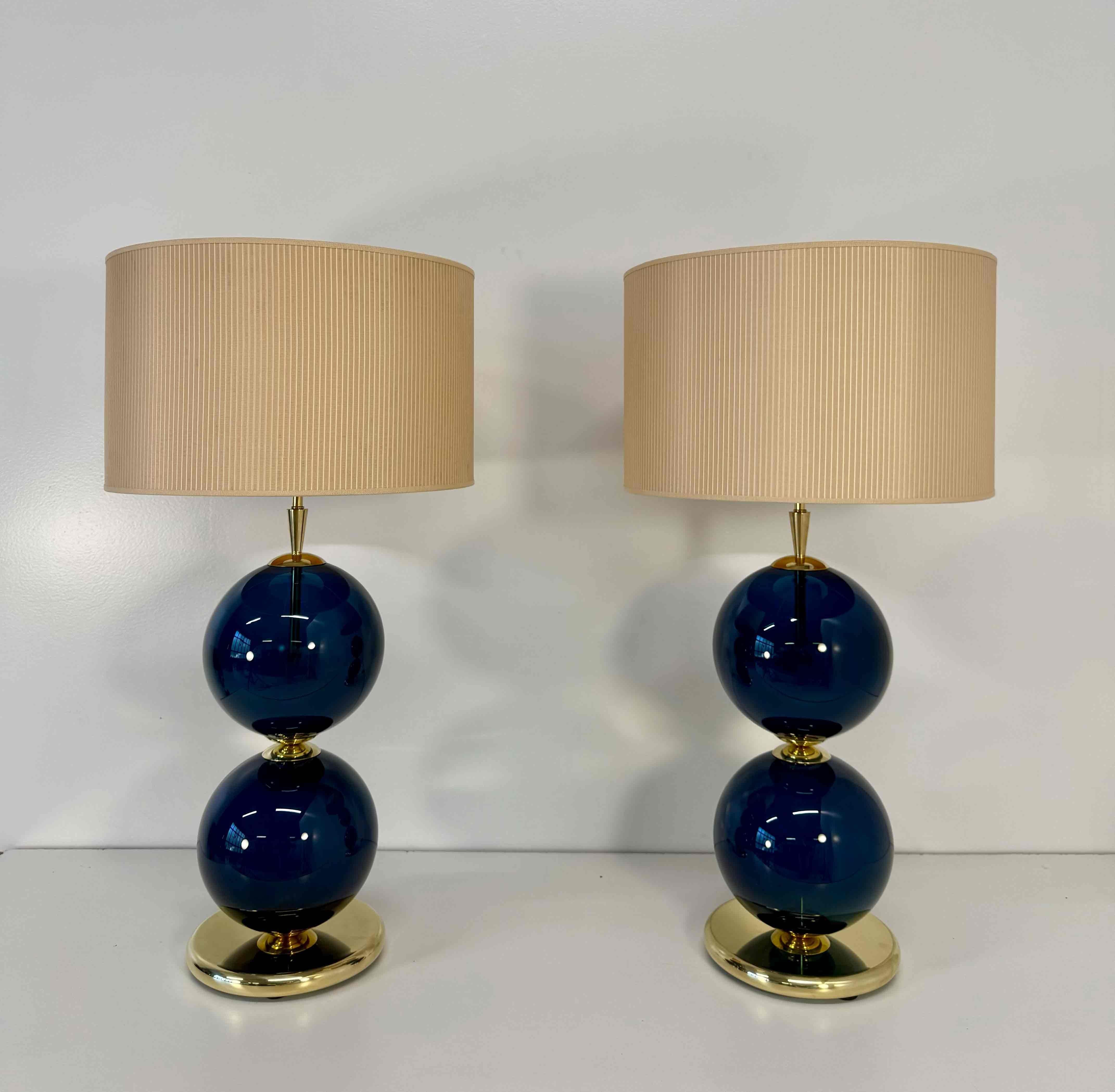 Cette élégante paire de lampes a été fabriquée à la main à Murano, en Italie, dans les années 2000.
Chaque lampe présente deux sphères en verre de Murano soufflées à la main dans une nuance raffinée de bleu, reposant sur un socle en laiton poli qui