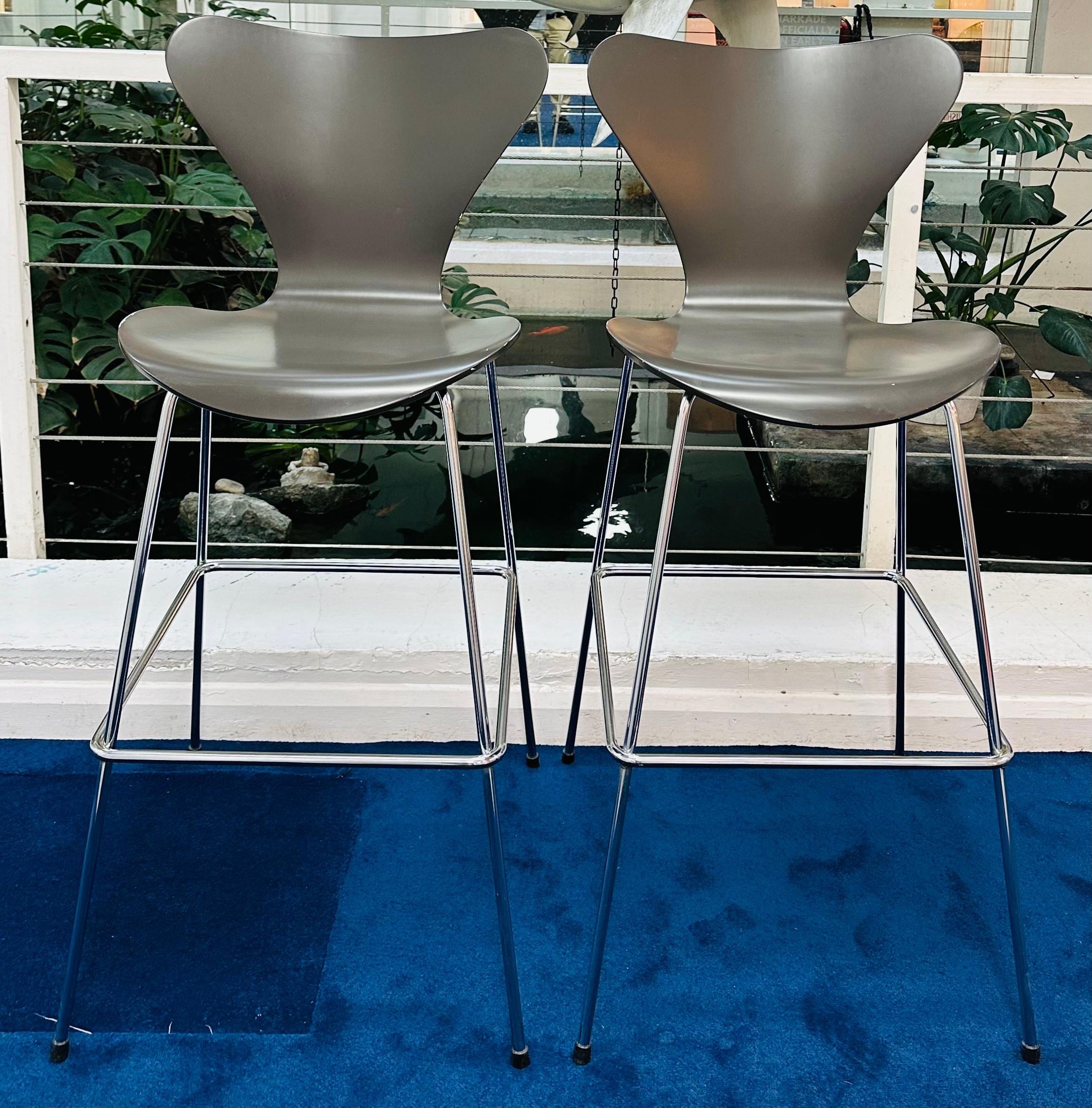Pair of Fritz Hansen Series 7 Bar Stools designed by Arne Jacobsen in 1955.  Year of manufacture 2005.

The seat is made from curved ash with a dark grey lacquered finish with chromed steel legs.  

In good vintage condition with some chips and