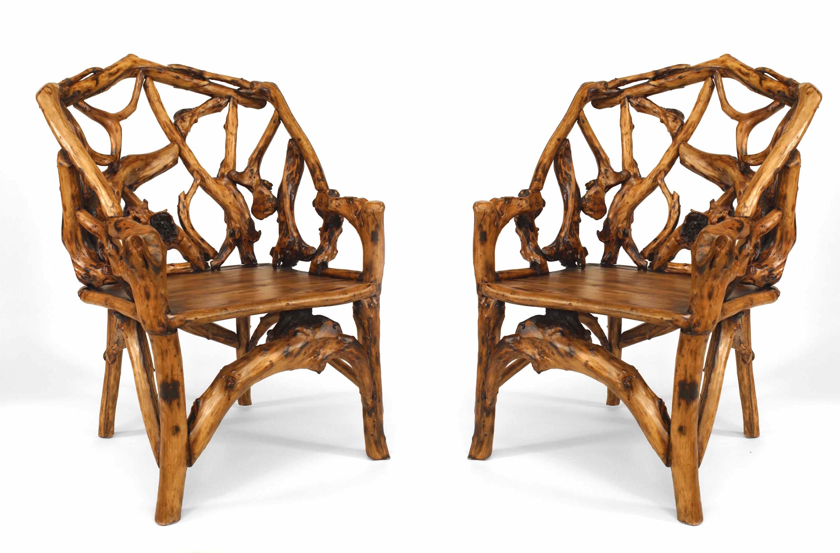 Pair of twentieth century rustic root armchairs each featuring a rounded back borne out of a web of interwoven roots above a plank seat and four legs.