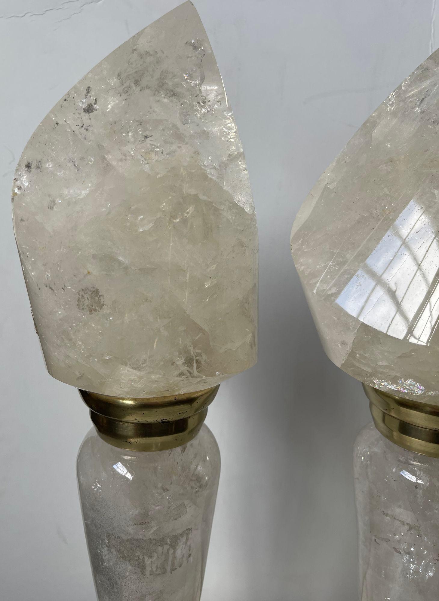 Superbe paire de lampes italiennes en cristal de roche du XXe siècle, incarnant l'élégance intemporelle avec leurs abat-jours de style flamme et leurs accents en laiton raffinés. Les lampes sont dotées de bases en cristal de roche finement