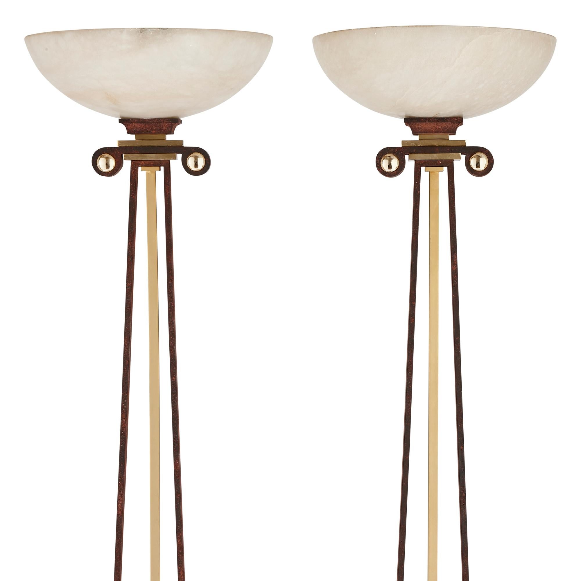 Pair of 20th century alabaster, gilt metal and iron floor lamps
Continental, 20th Century 
Height 185cm, diameter 40cm

Inspired by features of Greek architecture and made from a selection of high quality materials, the pair of floor lamps would add