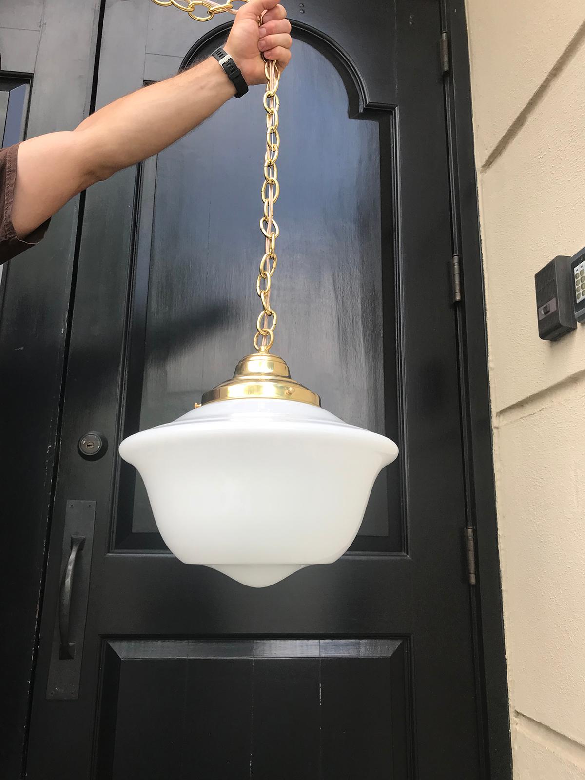 Pair of 20th century American milk glass pendant and brass hanging light fixtures.
