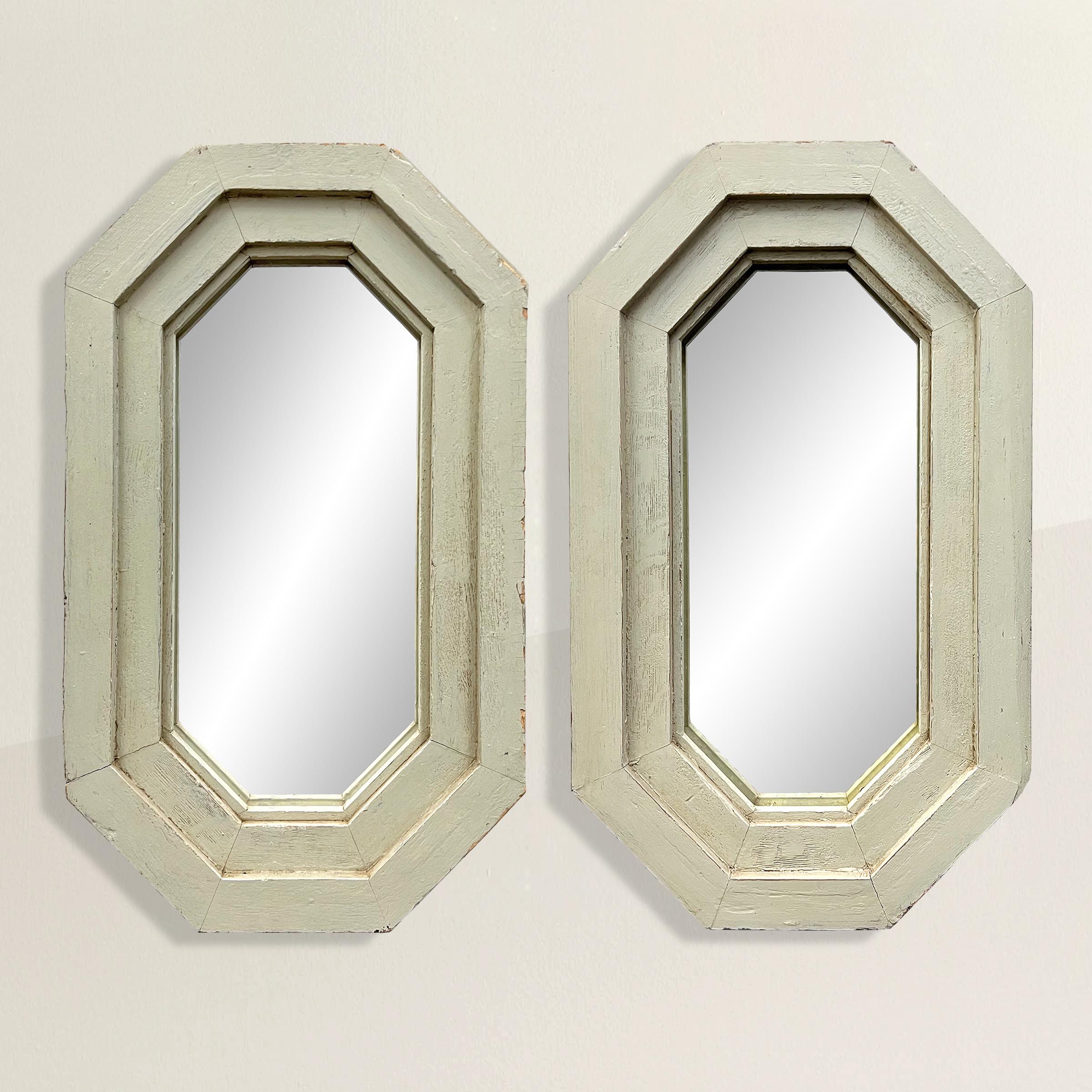 A chic pair of quirky and classical-inspired early 20th century American octagonal framed mirrored with a wonderful sage green painted finish and antique mirrors. Perfect over a pair of console tables or over a pair of bedside tables.