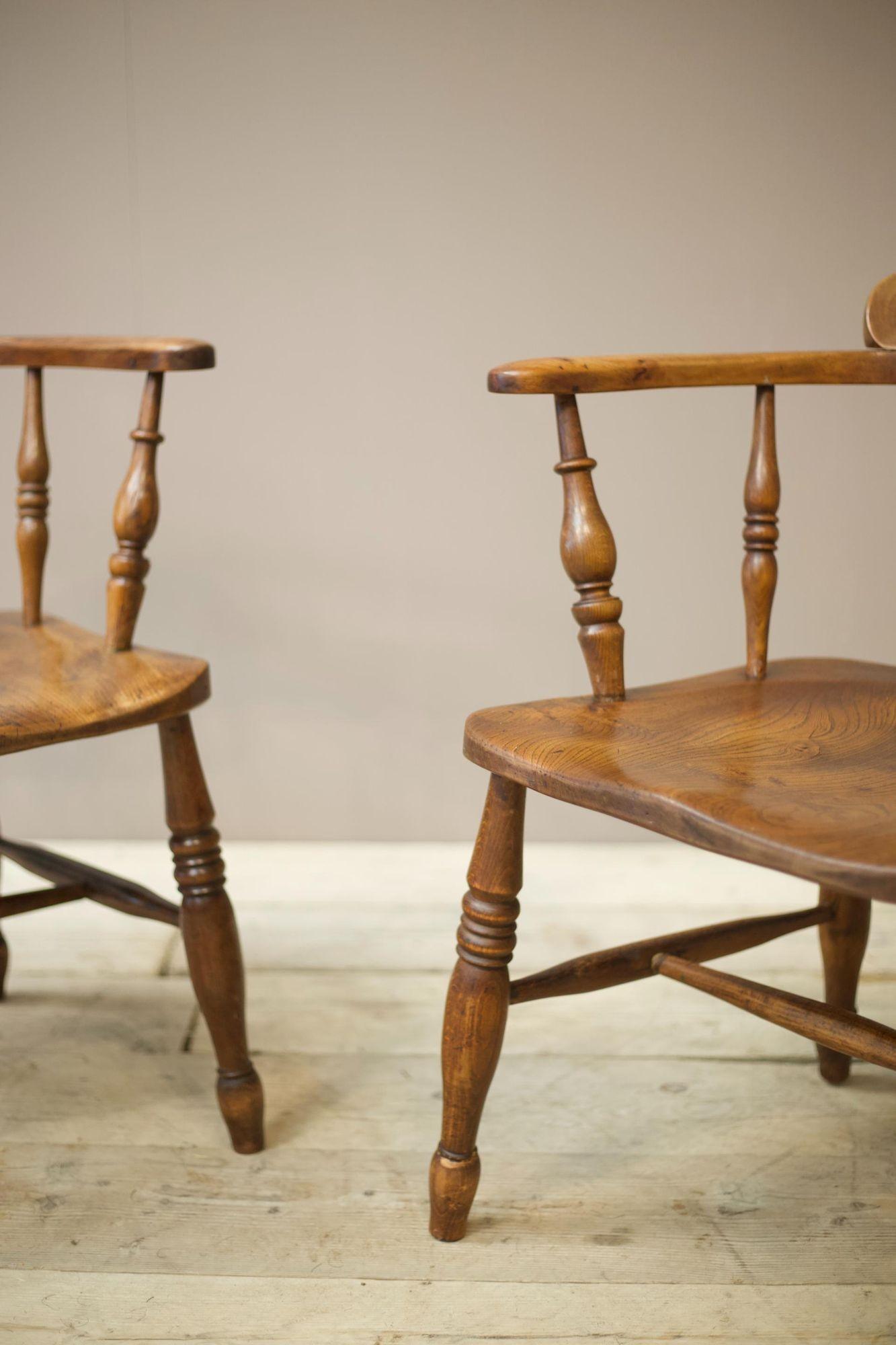 These are a very stylish pair of early 20th century Ash and Elm smokers chairs. They have wonderful figuring to the seats and great patina to the arms. These are in solid condition and are ideal for everyday use. The only thing to note is the legs