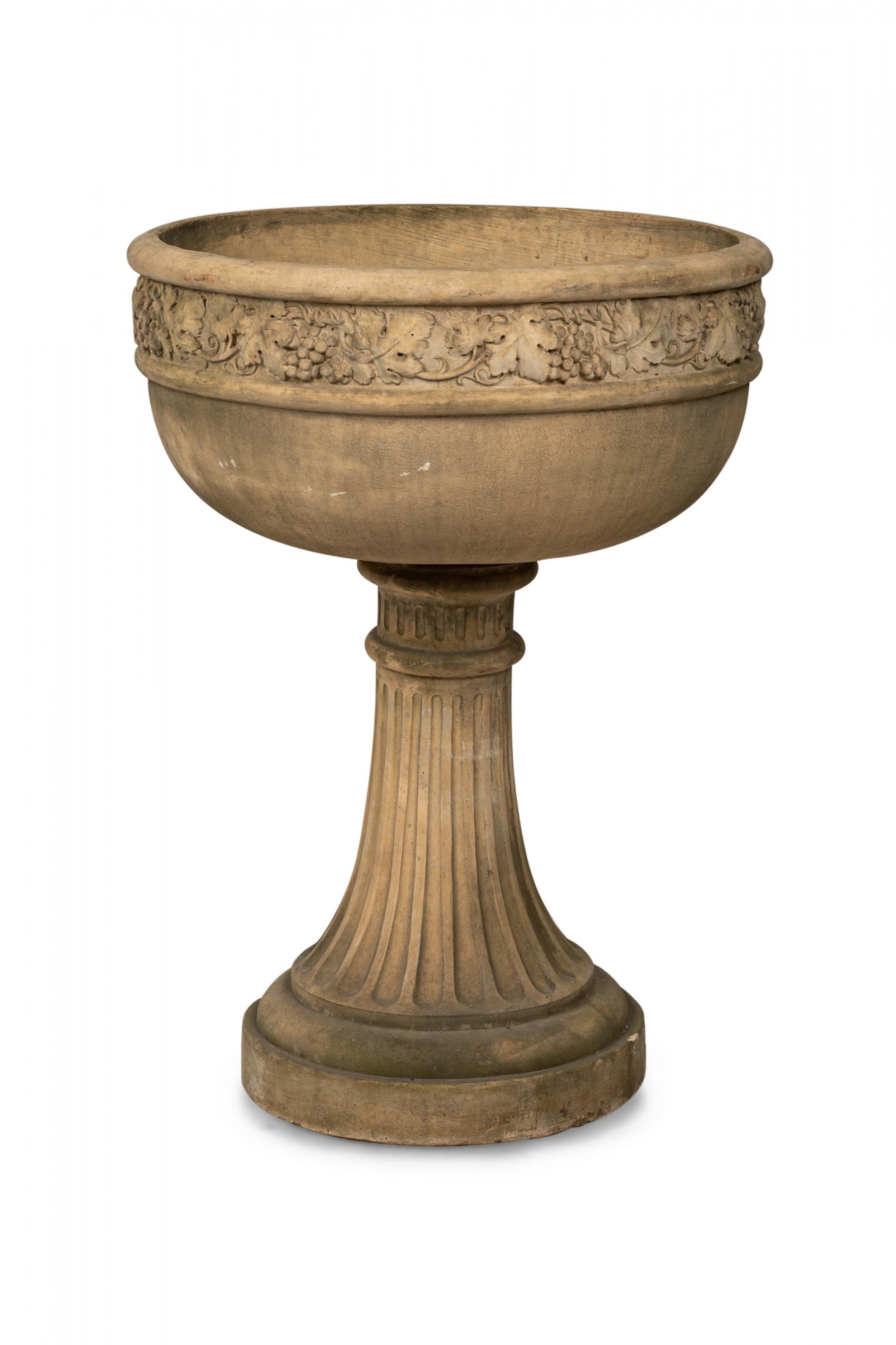 Pair of Contemporary (20th Century) large beige cast stone garden planters / outdoor urns with chalice form bowls featuring low relief decorative grapevine bands and drain holes to bowl, fitted on fluted circular bases.
