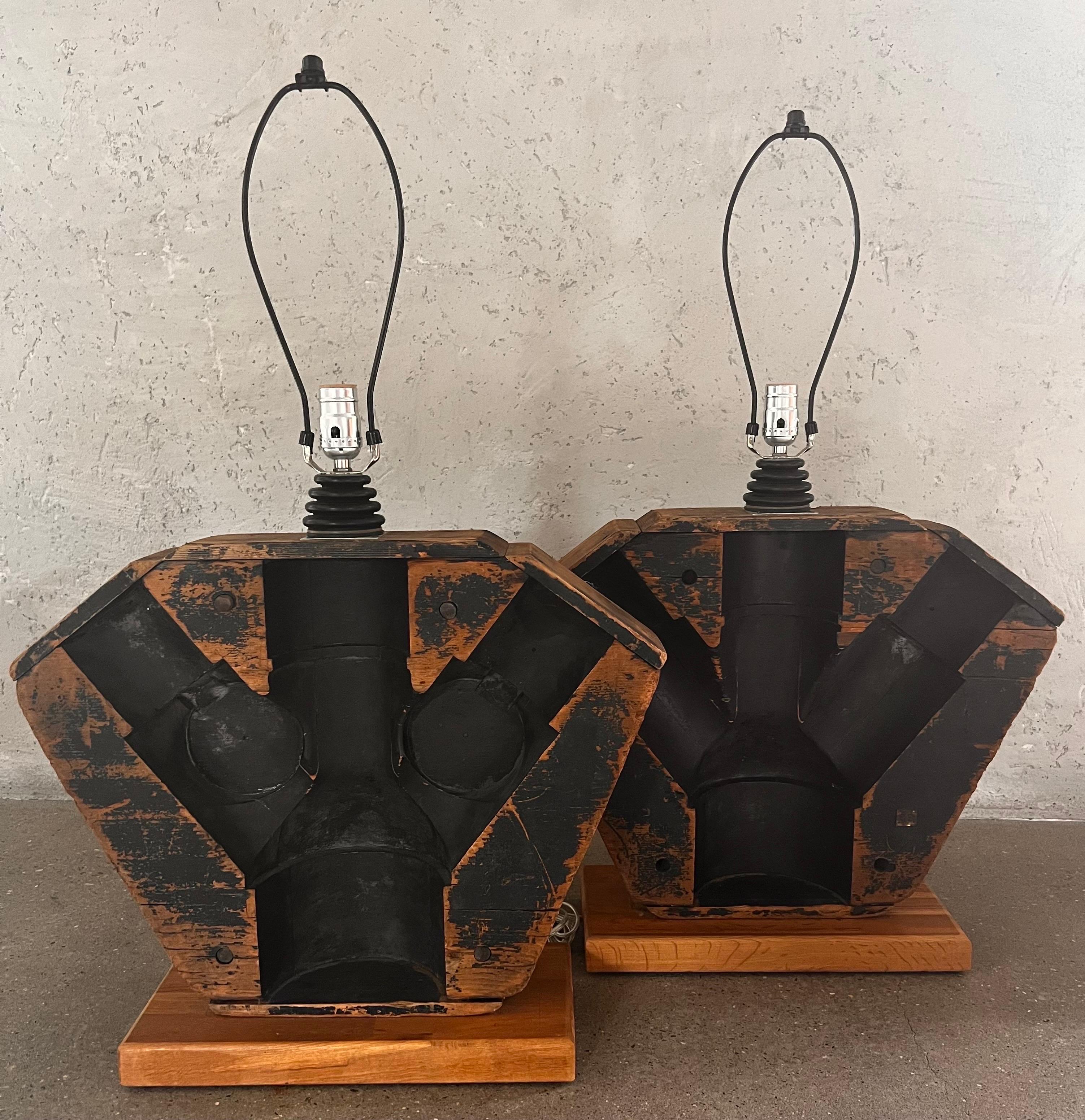 The gear lamps are massive and quite interesting. Black paint which appears to be India ink is very dark and works well against  the warm brown wood tones. Industrial and very chic. Black rectangular shades included. 