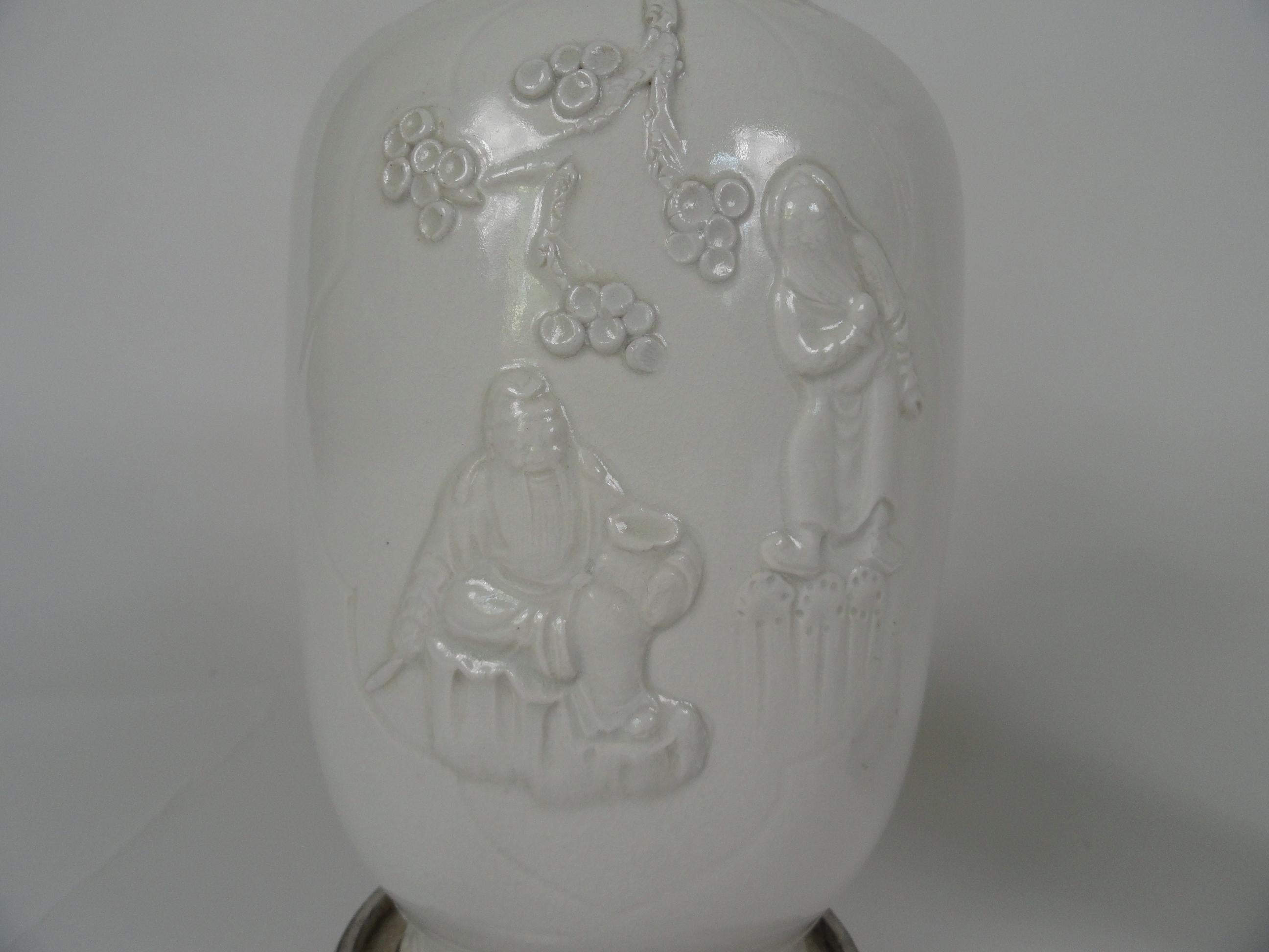 Pair of 20th century Blanc de Chin vases with elephant handles and applied decorations.
