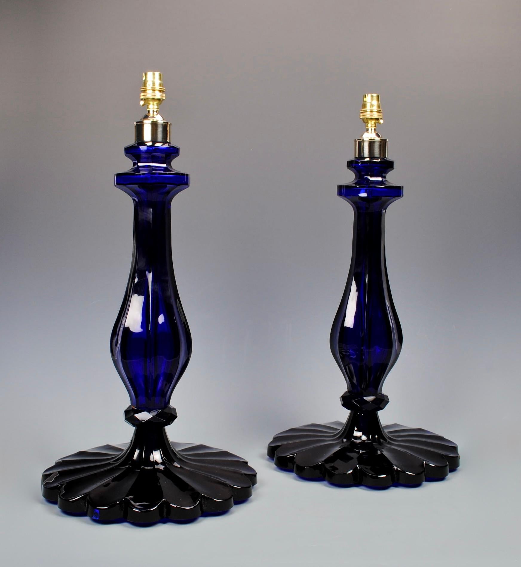 A superb pair of cobalt blue cut glass table lamps, each with moulded faceted baluster stems, and scalloped base.

Height: 19 in (48.5 cm) excluding electrical fitments and lampshades.

All of our lamps can be wired for use worldwide. A