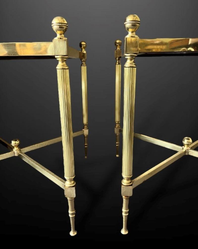 Paire d'étagères ou de tables d'appoint en laiton et cuir du 20e siècle. 

Les plateaux en cuir vert sont dorés et ornés de fleurons en laiton tourné à tous les angles. Ils reposent sur des pieds fuselés cannelés.