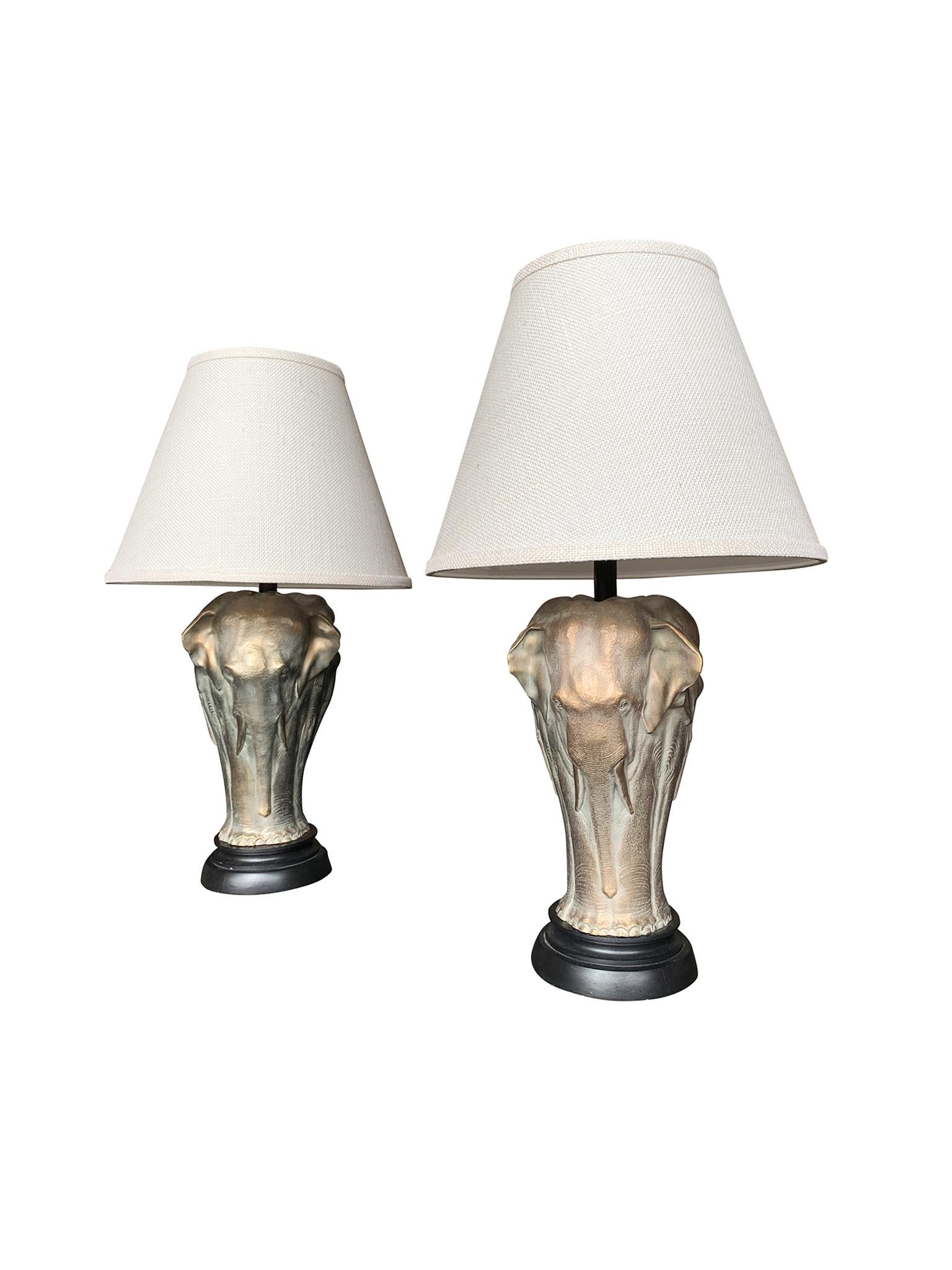 A charming pair of table lamps in cast bronze. Crafted, 20th century. The lamps are designed in the shape of elephants, each lamp being a cluster of three and forming a column. The bronze has a gold patina that gives the surface a nice luster, while