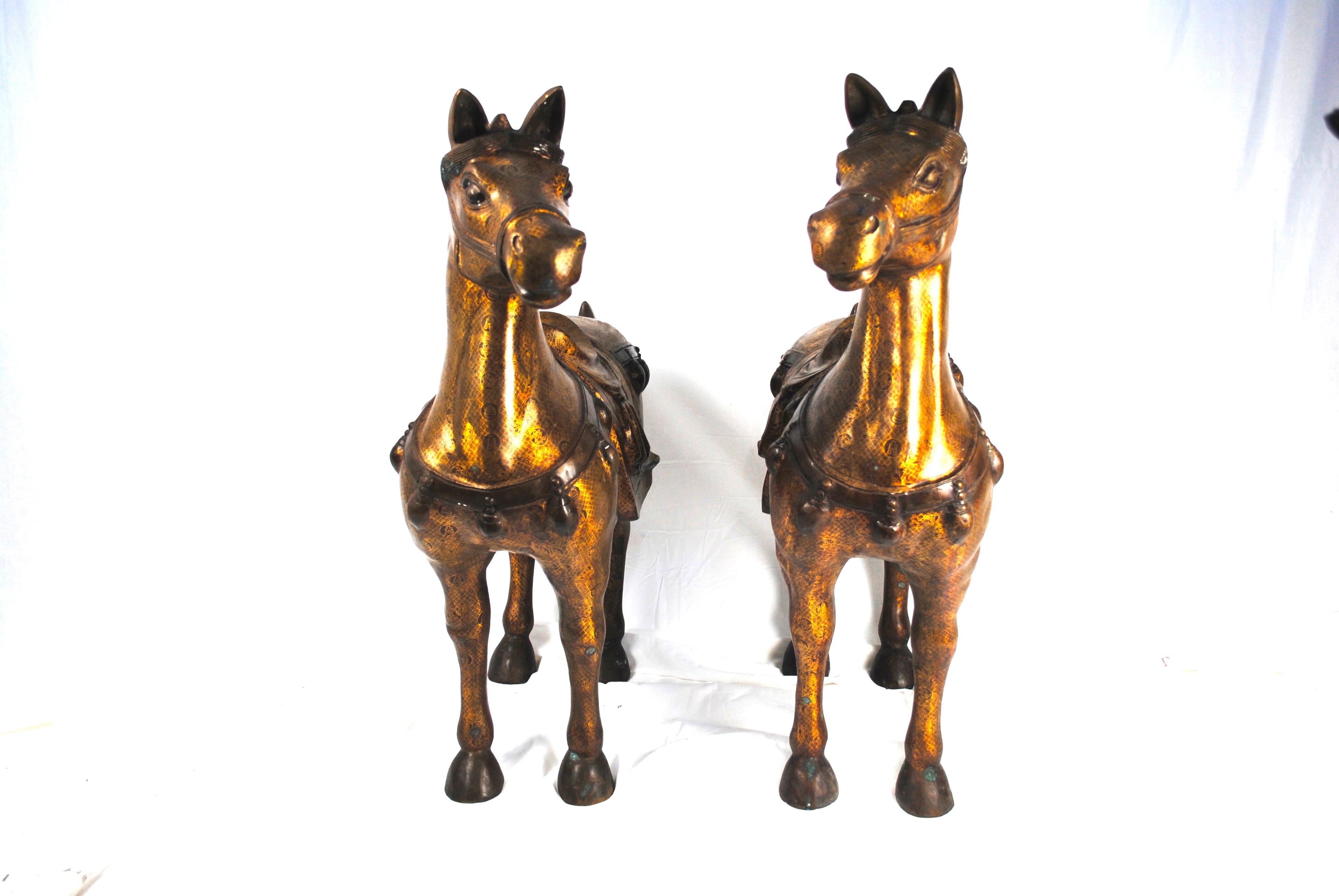 A pair of 20th century bronze gilded gift horses.
Lavish pair of cast brass and gold gilt horse statues or sculptures made in the Chinese Tang dynasty style. Features intricately cast bodies with detailed Chinese characters echoed over the both