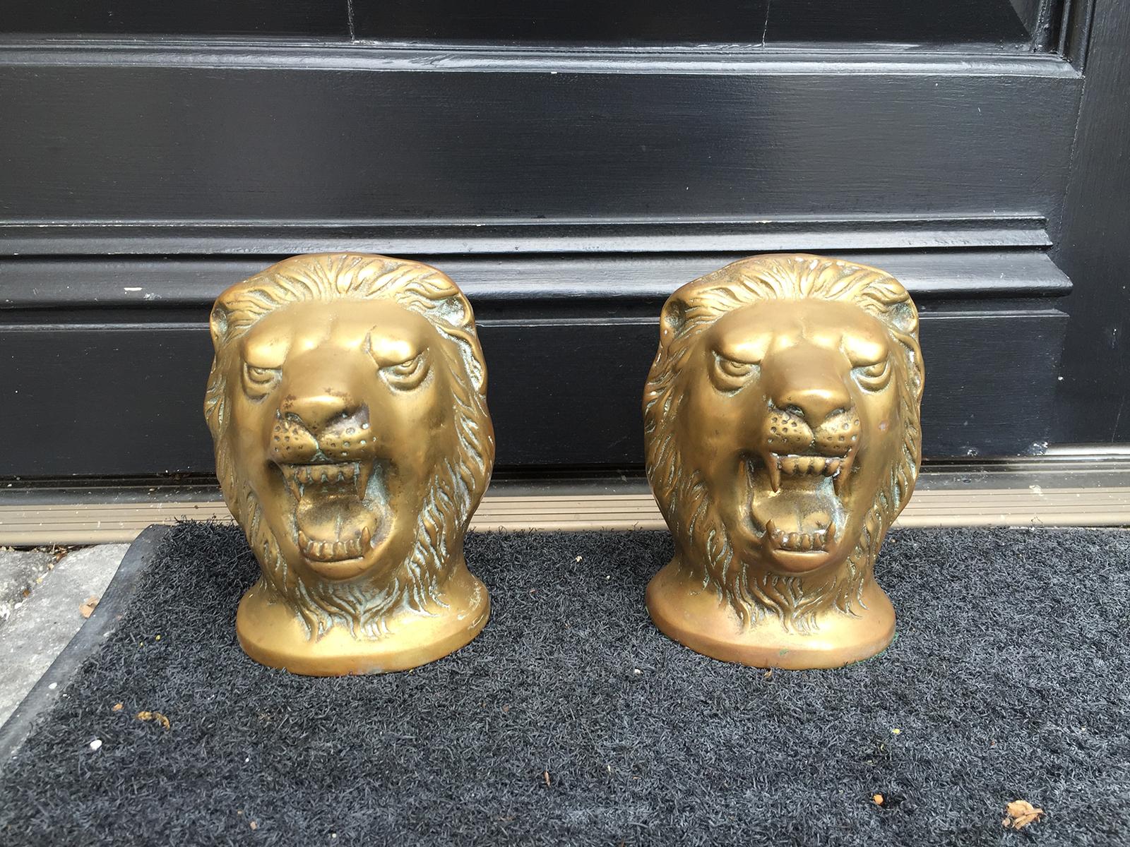 Pair of 20th century bronze lion head paperweights.