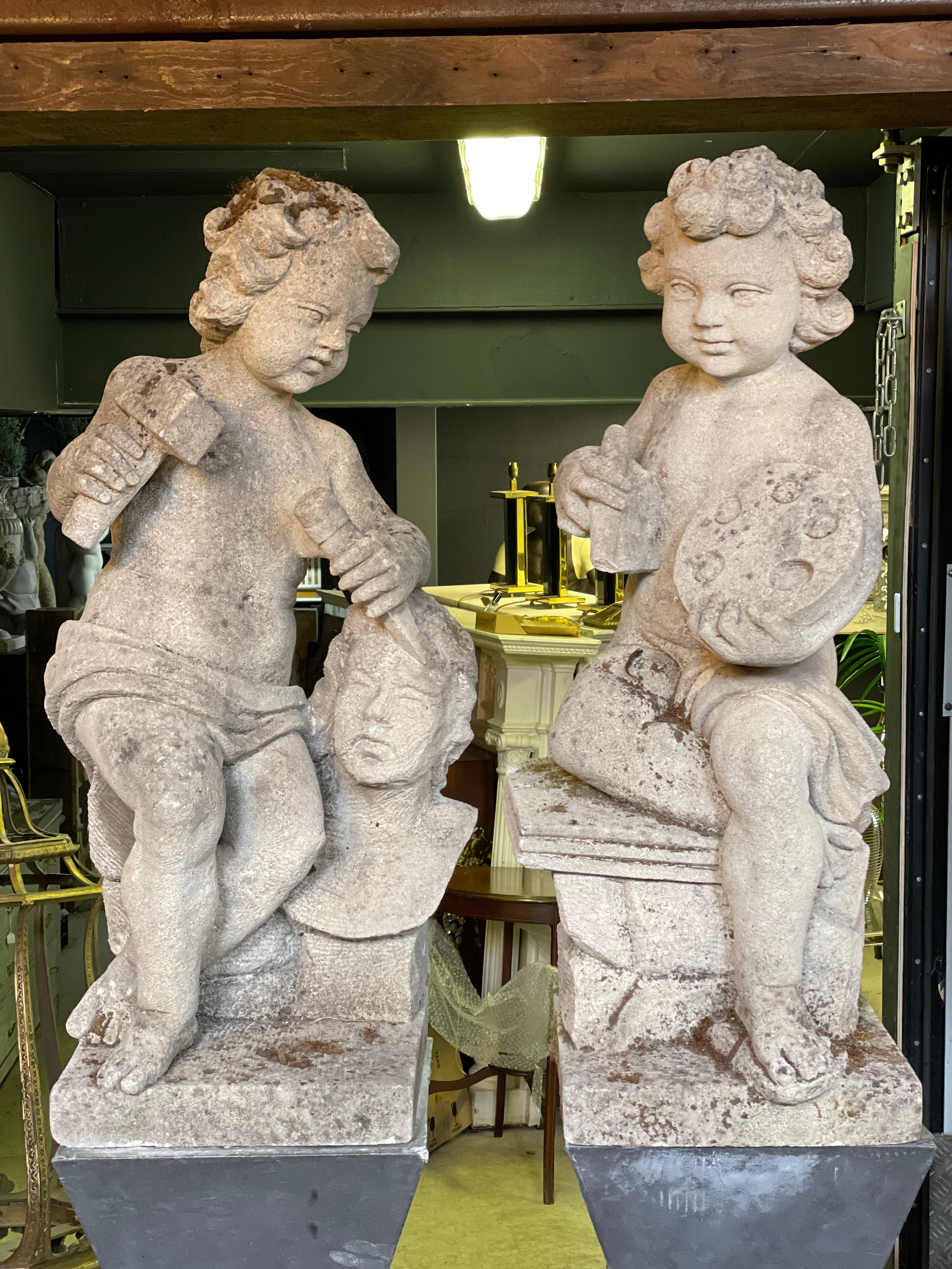 A stunning pair of 20th century carved stone Putti.

One of the Putti is busy carving a bust while the other Putti appears to have a set for painting.