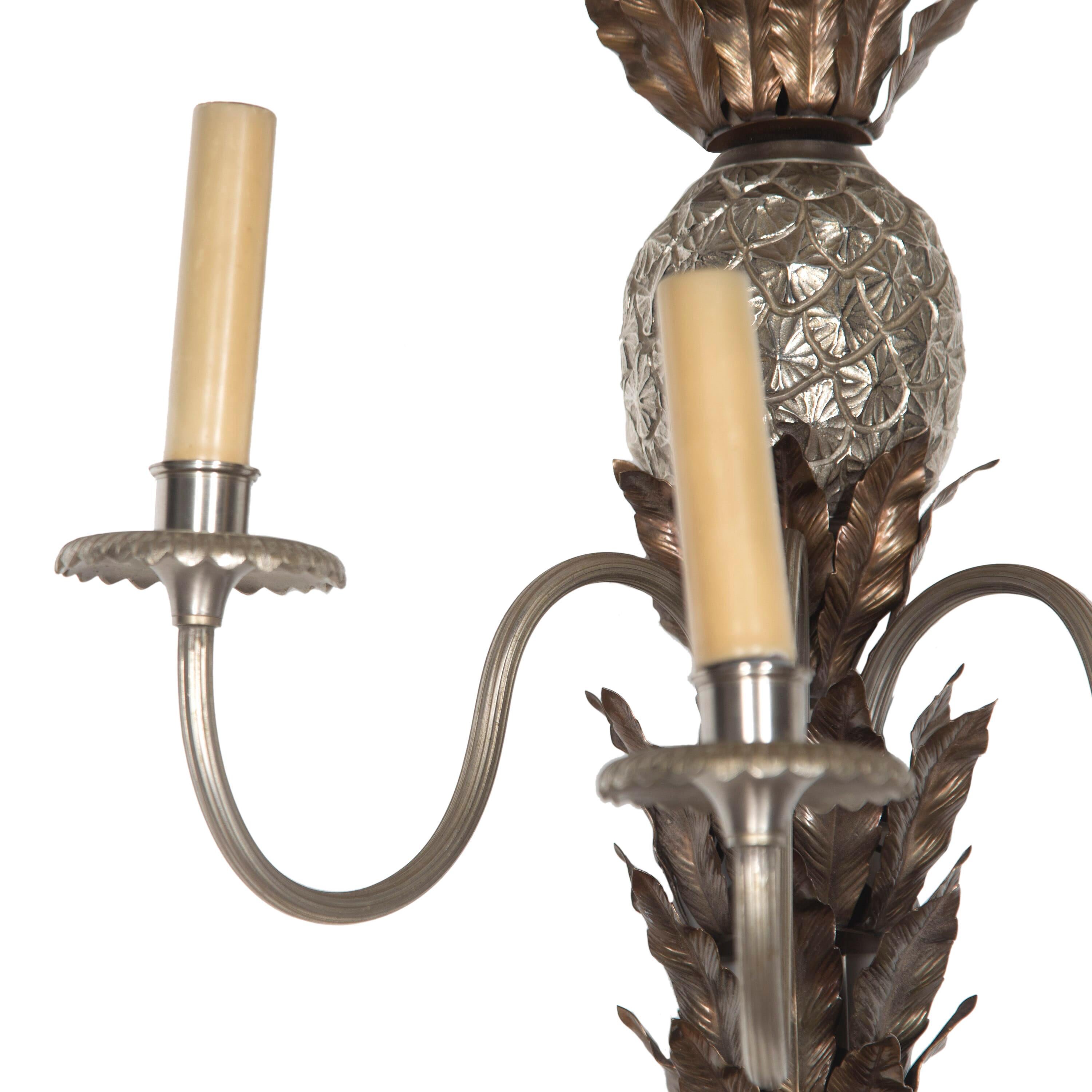 A pair of early 20th century pineapple wall lights. The quality casting gives decorative definition to the pineapple and leaves. This piece has been rewired and PAT tested to UK standard.