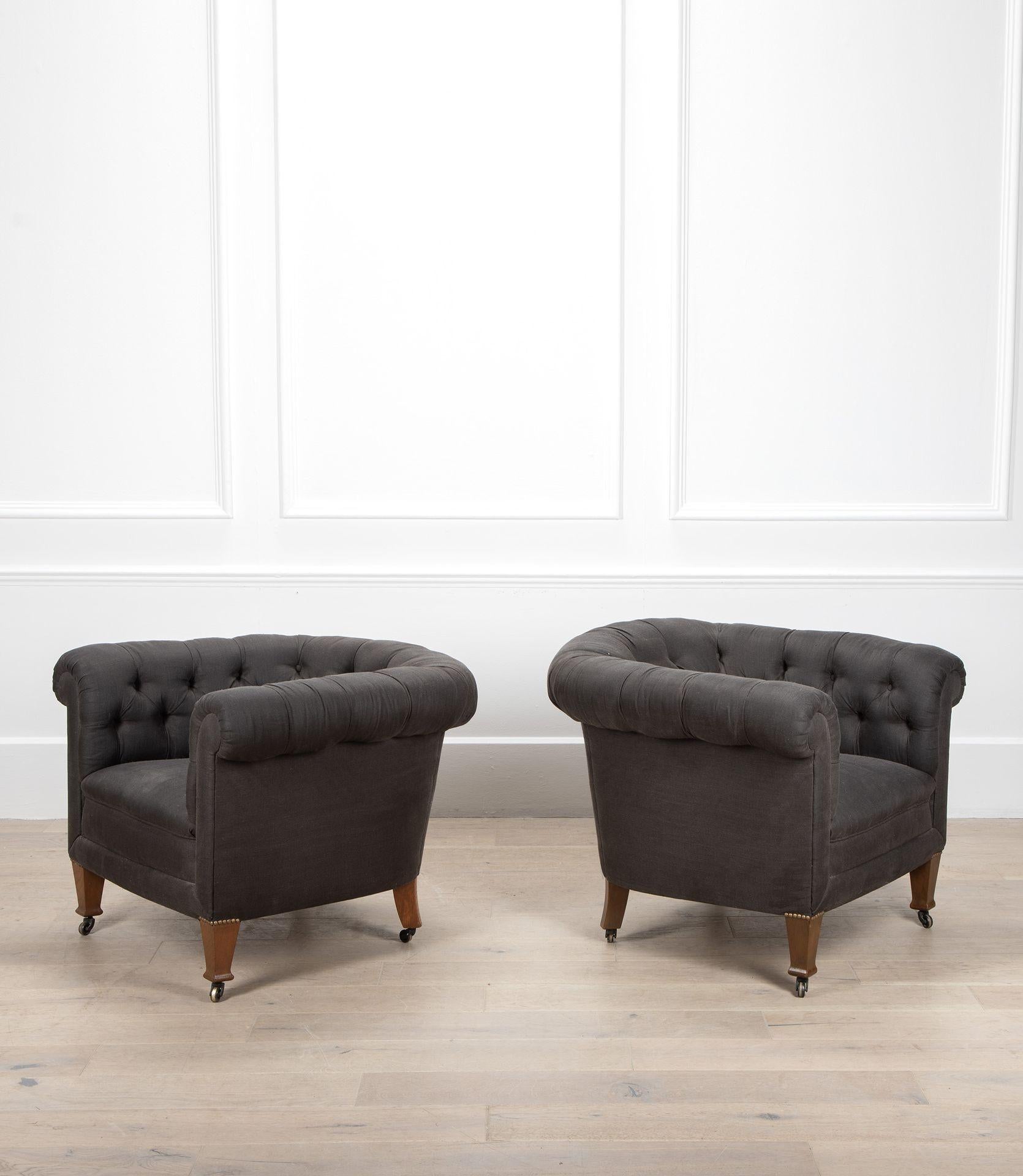Paire de fauteuils Chesterfield du 20e siècle, de proportions généreuses, tapissés de lin gris et dotés d'un dossier à boutons.
Sur pieds coniques carrés et roulettes en laiton.
