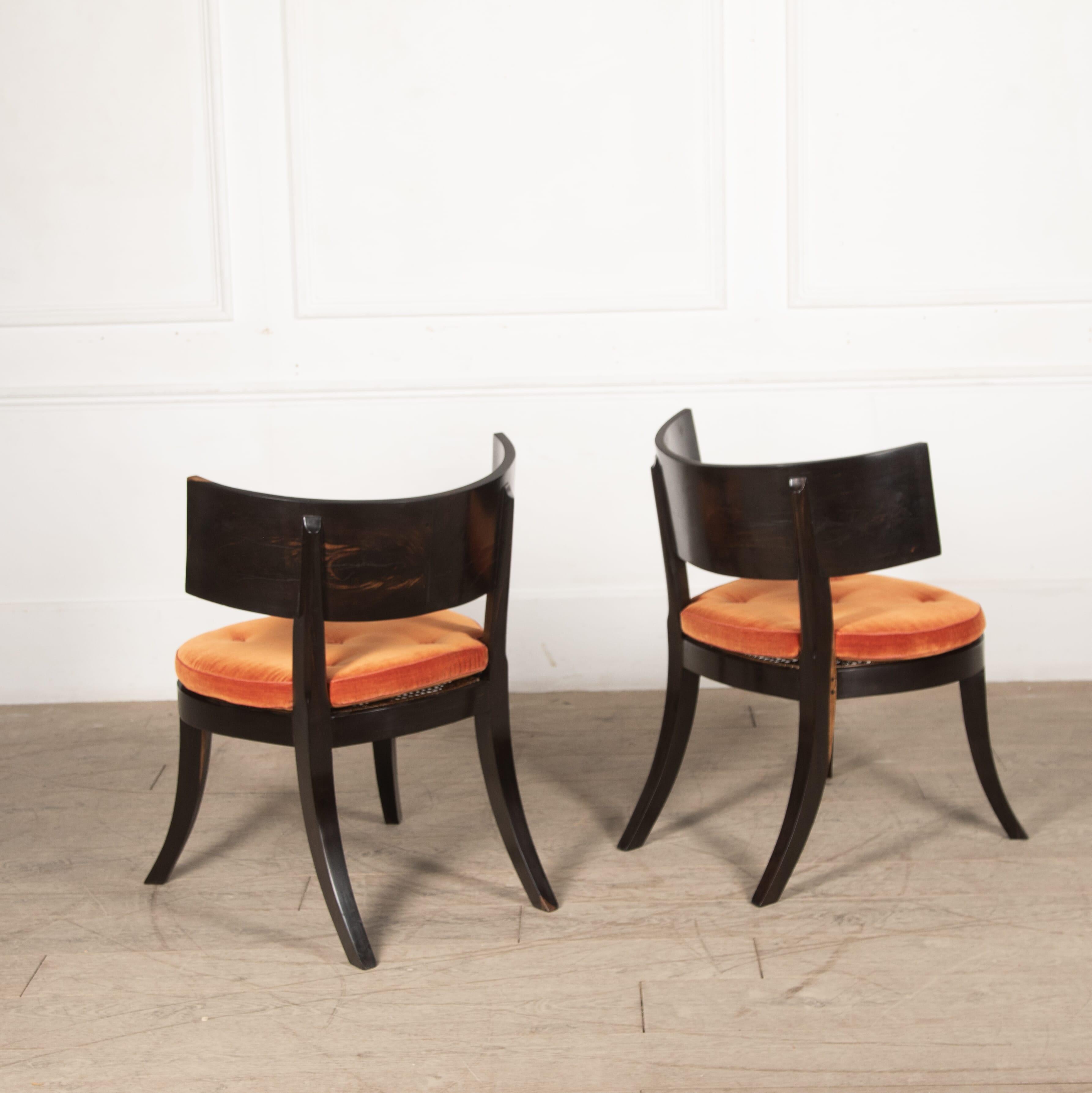 Pair of 1970's Indian solid coromandel klismos side chairs.
With orange/coral cushions on a cane seat, some signs of wear commensurate with age.