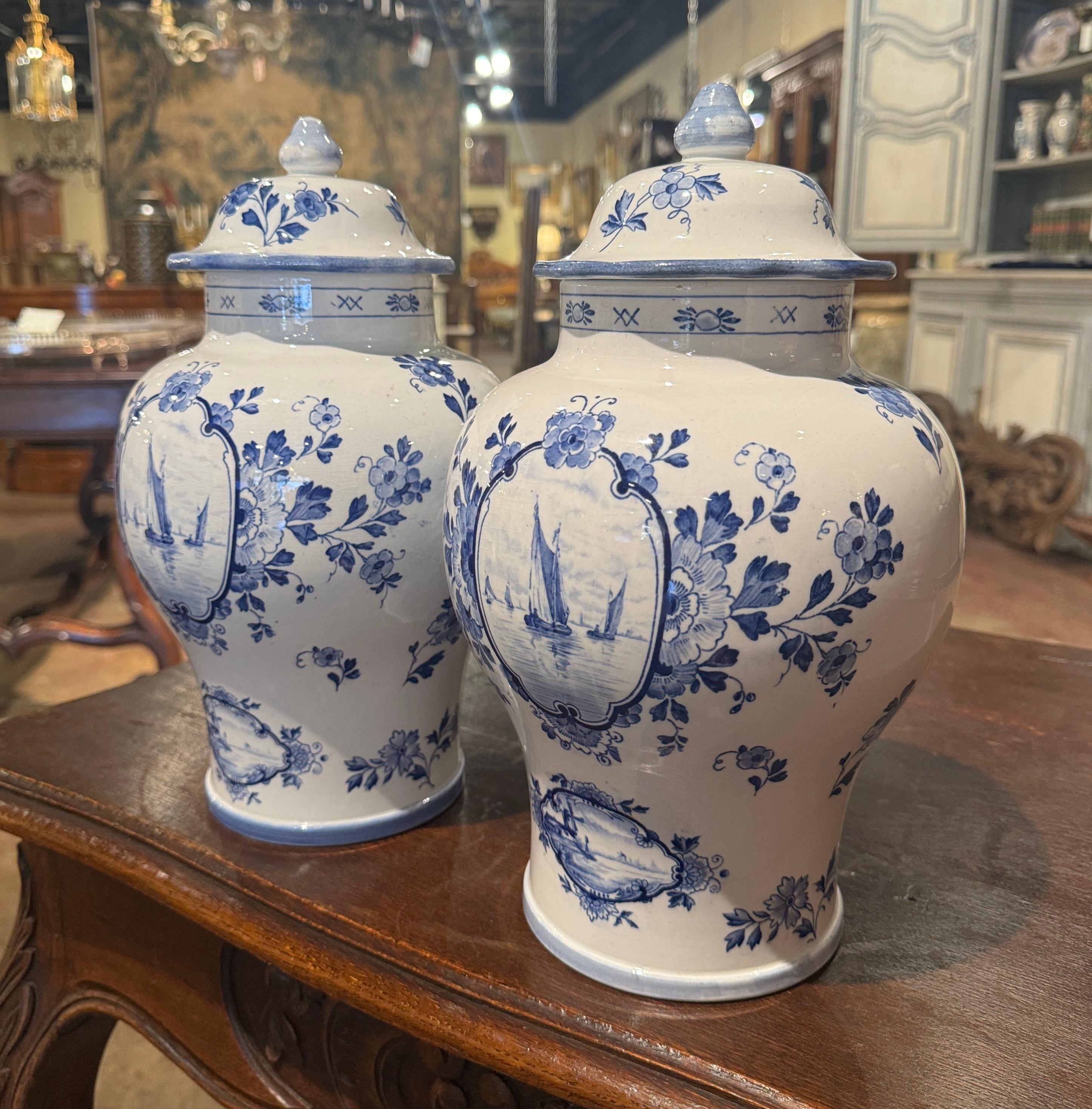 Placez cette élégante paire de pots à gingembre en céramique antique sur une cheminée ou une console dans l'entrée. Fabriquées en Hollande vers 1980, ces jarres traditionnelles bleues et blanches sont de forme ronde et possèdent un couvercle conique