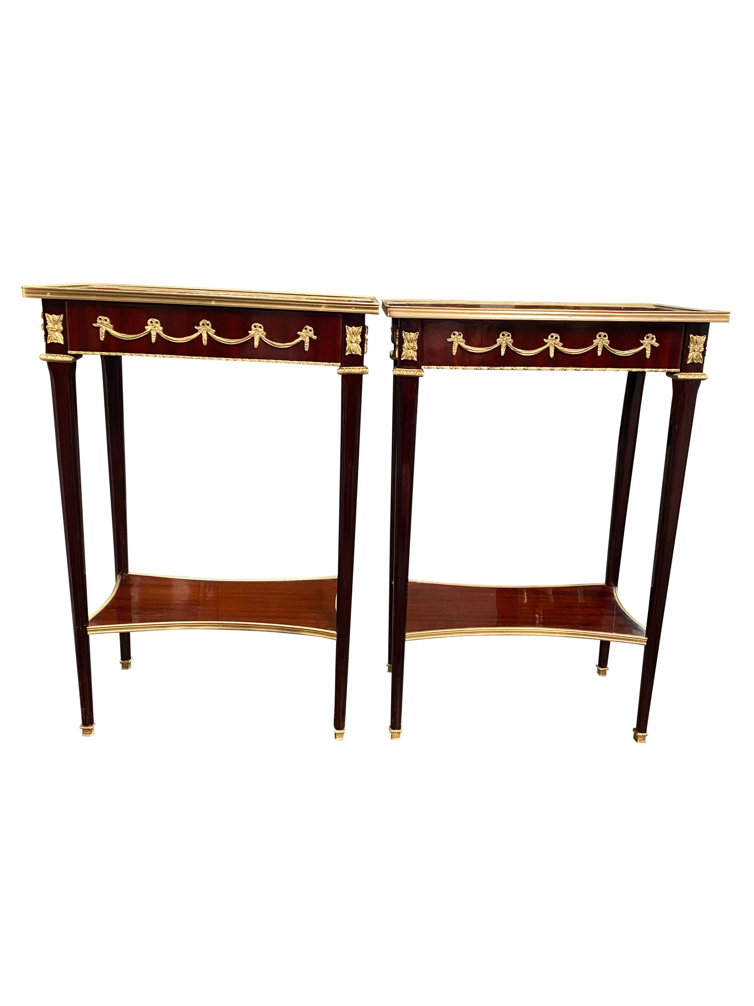 A stunning pair of 20th century Empire style side tables. A gorgeous and elegant design perfect for modern interiors.