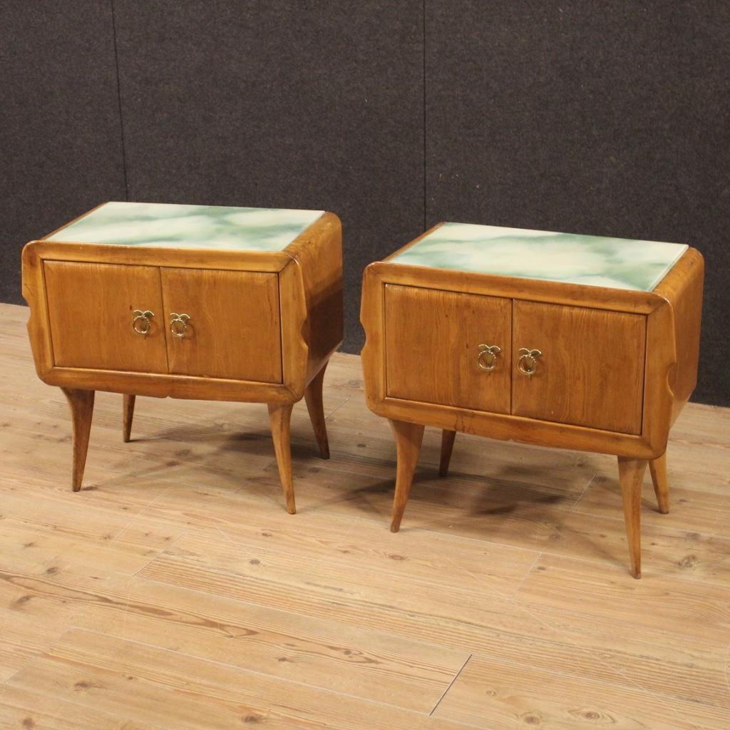 Pair of Italian design bedside tables from the 1960s. Exotic wood carved and veneered furniture with original glass top adorned with faux marble decoration (see photo). Beautiful bedside tables of pleasant decor equipped with two front doors with