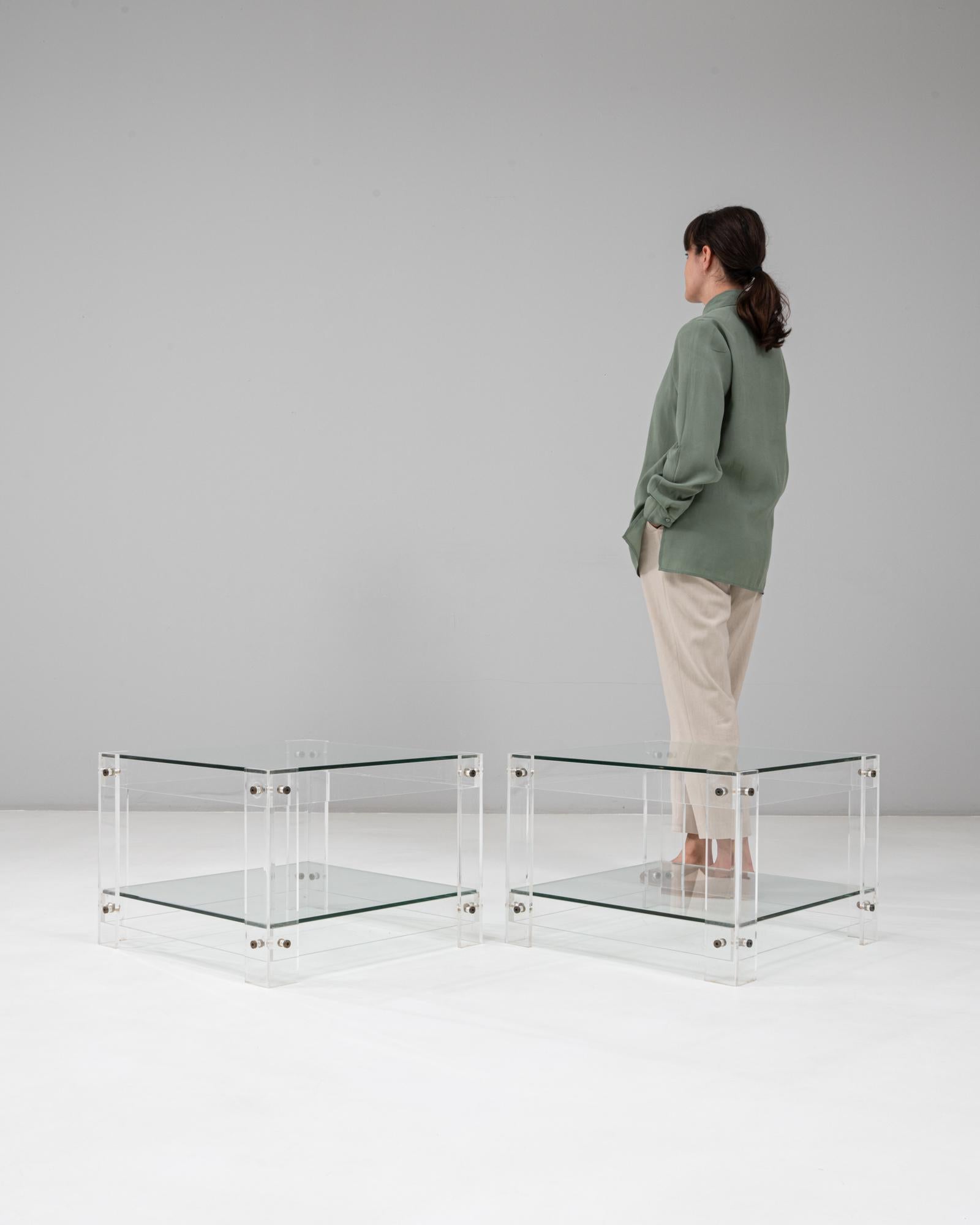 This pair of 20th Century French acrylic and glass “Button Line” side tables embodies the clean, playful precision of late-modern design. Each table is constructed from clear acrylic supports joined with exposed circular fasteners— the signature
