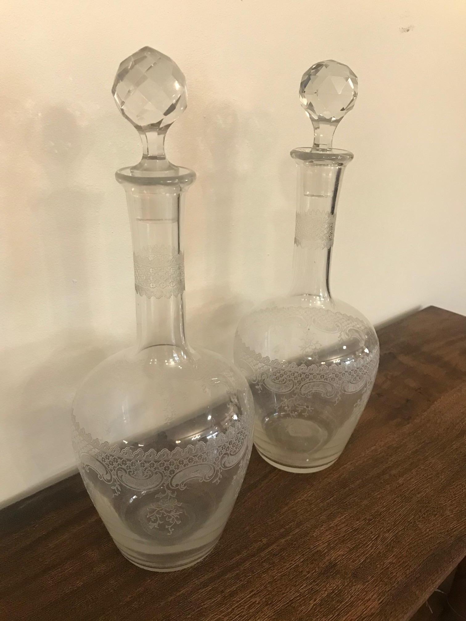 Beautiful pair of 20th century French engraved crystal carafes from the 1900s. 
Very nice engraved details. 
Removable plugs also cut in crystal. 
Exceptional quality and good condition. Has numbers engraved at the top and also on the plug.