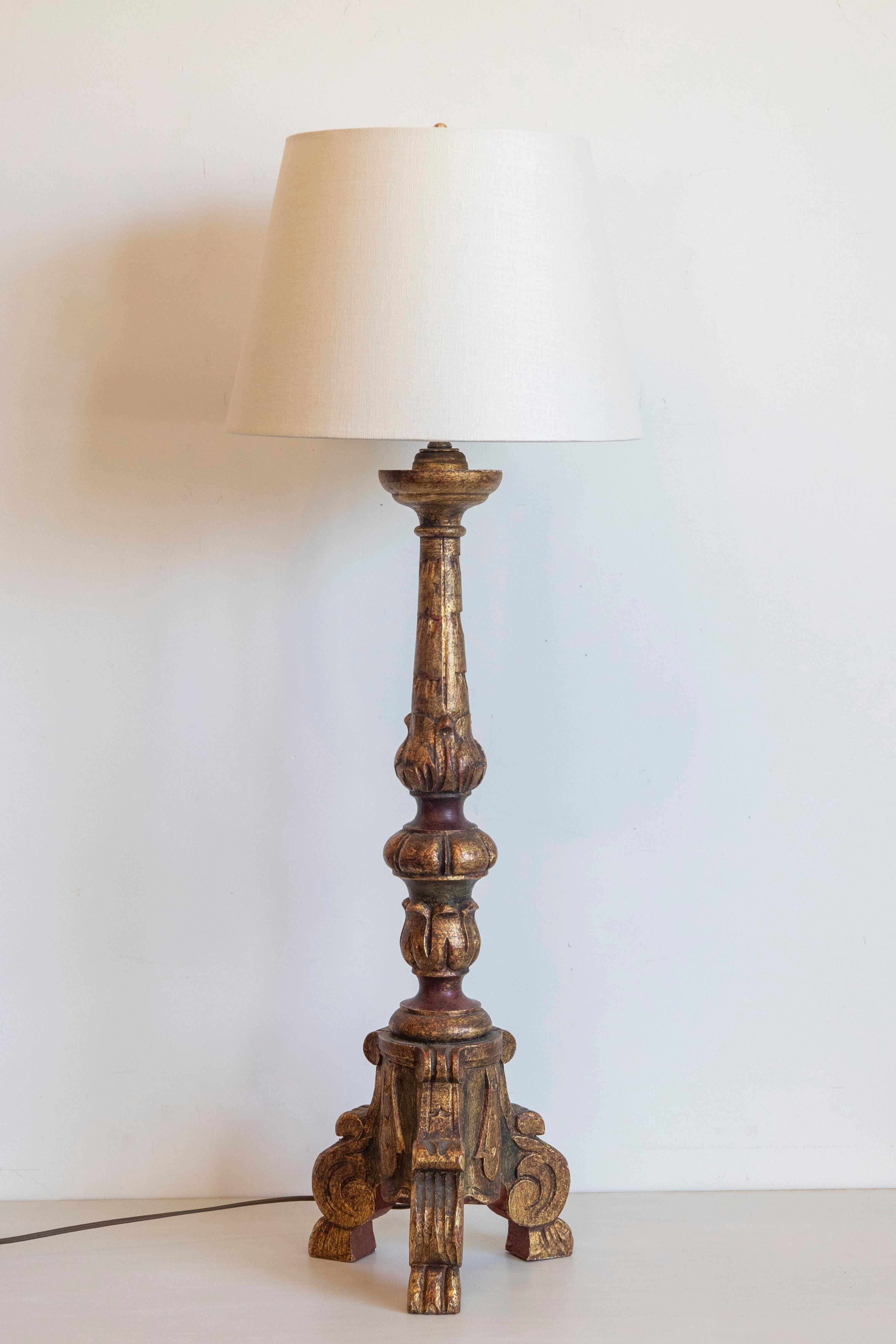 Cette impressionnante lampe de table présente un design saisissant du milieu du XXe siècle, fabriqué à partir de bois doré et peint en polychromie. Le riche rouge foncé et la finition émaillée de bronze mettent en valeur sa forme sculpturale,