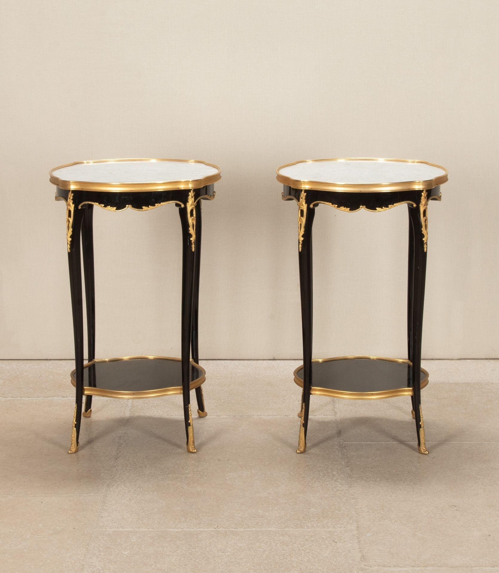 A stylish pair of mid-20th Century French ebonised and gilt bronze mounted side or lamp tables. With inset white marble tops, supported by gently tapering cabriole legs and a lower ebonised shelf. All beautifully mounted with crisply cast foliate
