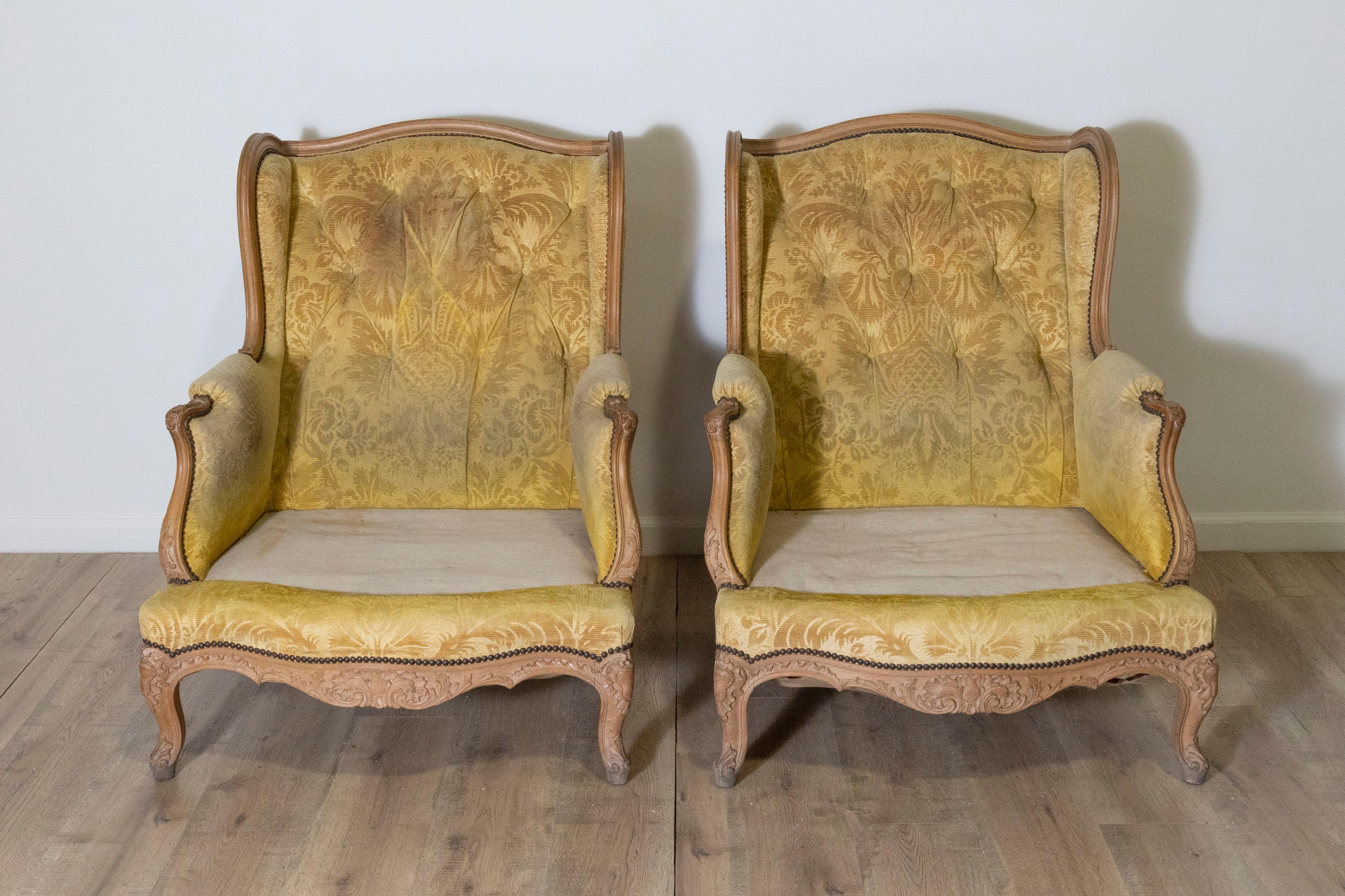 Cette élégante paire de chaises bergères françaises de style Louis XV du XXe siècle est fabriquée en noyer massif, un bois prisé pour sa durabilité et ses capacités de sculpture complexes. Les cadres présentent des lignes gracieusement incurvées,
