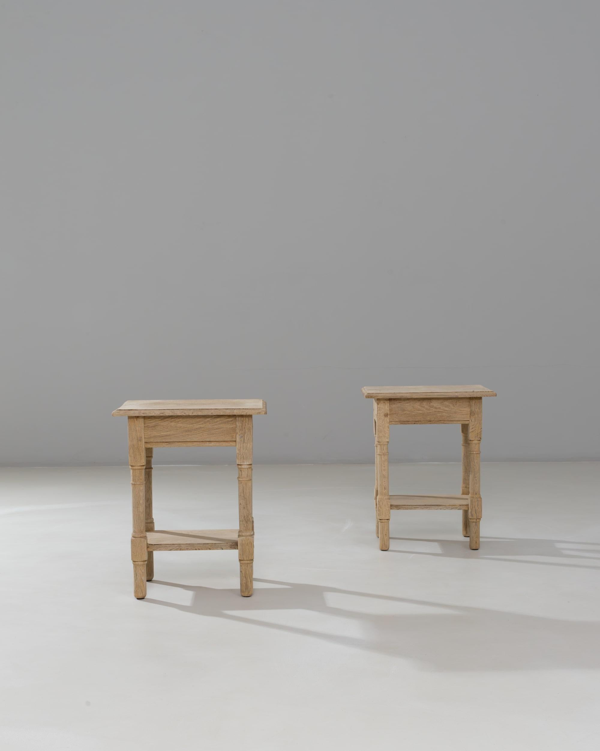 Cette paire de tables basses en chêne de style provincial français du XXe siècle présente le charme et la simplicité caractéristiques de l'artisanat provincial. Chaque table présente un plateau carré aux bords doucement arrondis, soutenu par des