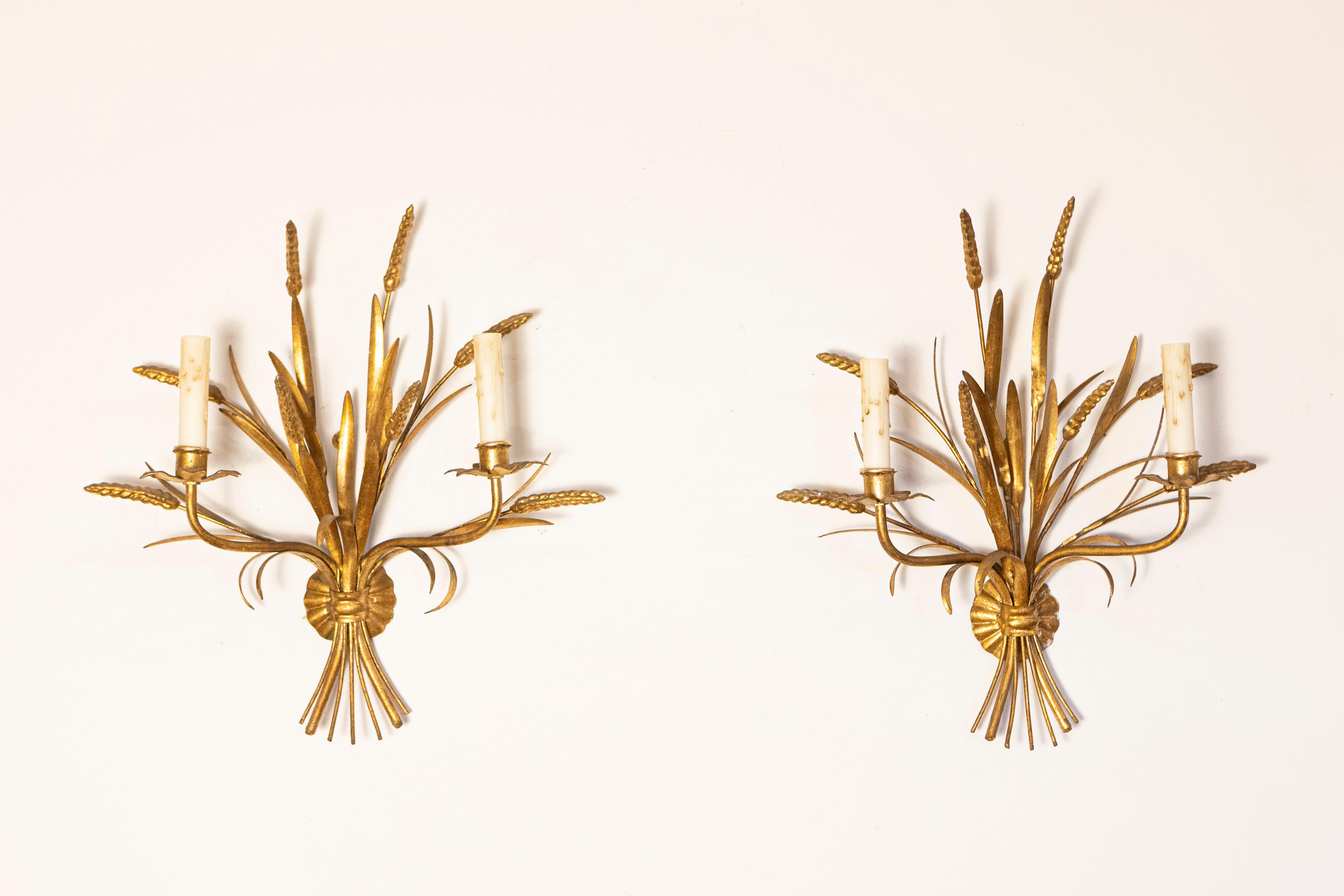 Cette élégante paire d'appliques françaises du XXe siècle, inspirée par Coco Chanel, dégage une sophistication et un charme intemporels. Fabriquées en métal doré, ces appliques présentent un étonnant motif de gerbe de blé qui symbolise l'abondance