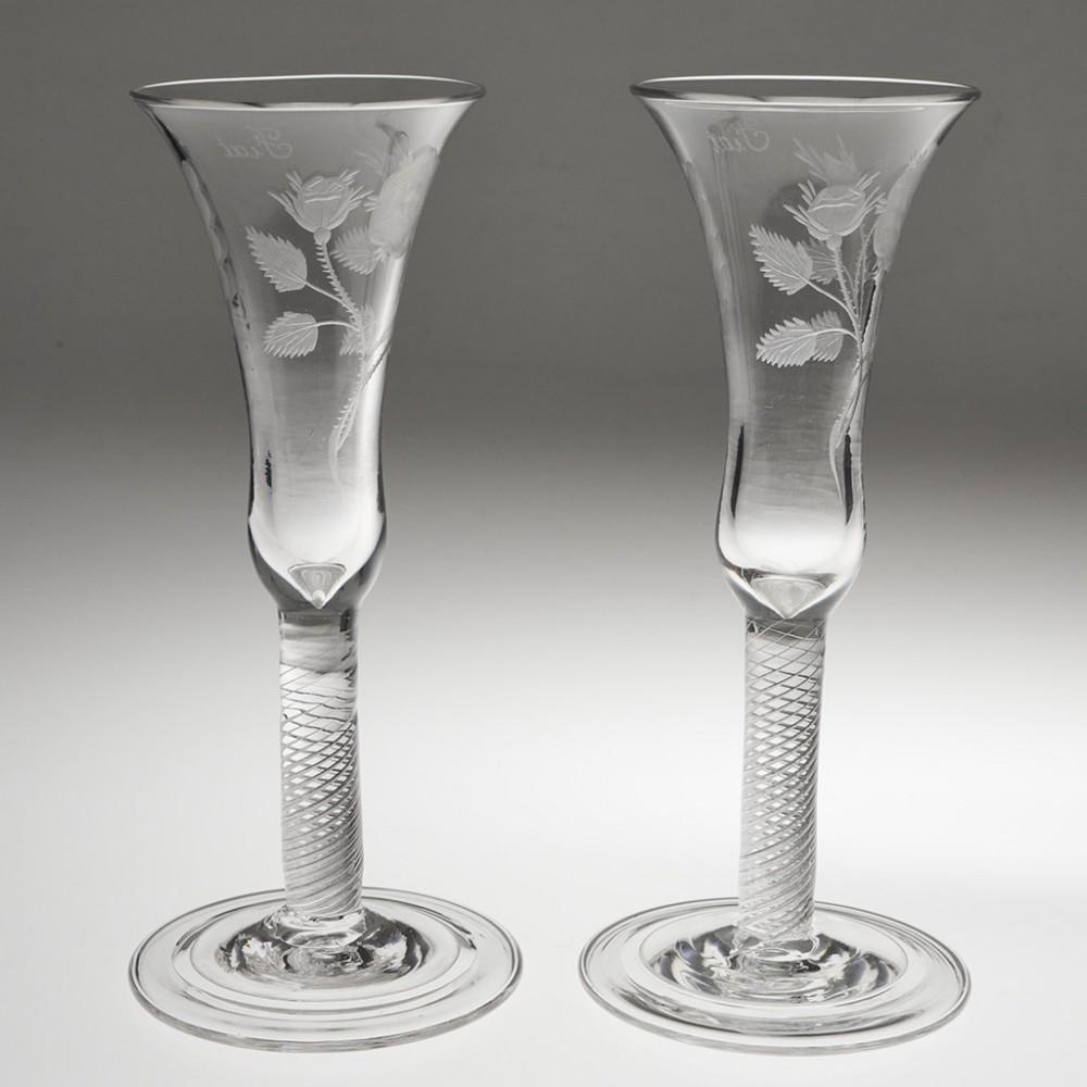 Heading : Pair of 20th century Georgian style Jacobite wine glasses
Period :  George V - c1935
Origin : England 
Colour : Clear with grey hue
Bowl : Waisted bell - Engraved with a rose, one open and one closed bud with an oak leaf and the motto