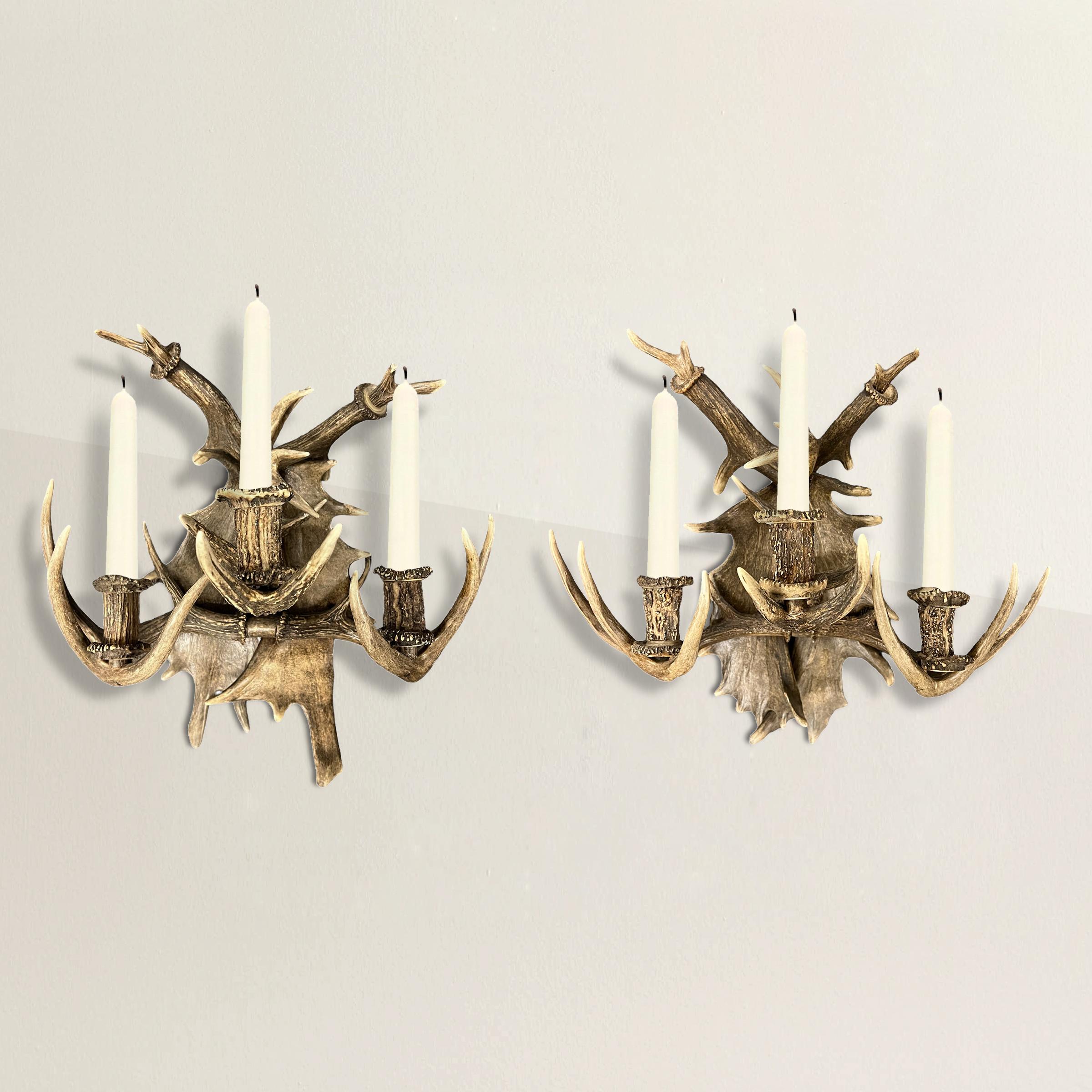 Crafted from fallow deer and stag antlers, these 20th-century German three-arm sconces stand as majestic relics of the Black Forest's heritage. Likely adorning the walls of a hunting lodge while flanking grand paintings or mirrors, their impressive