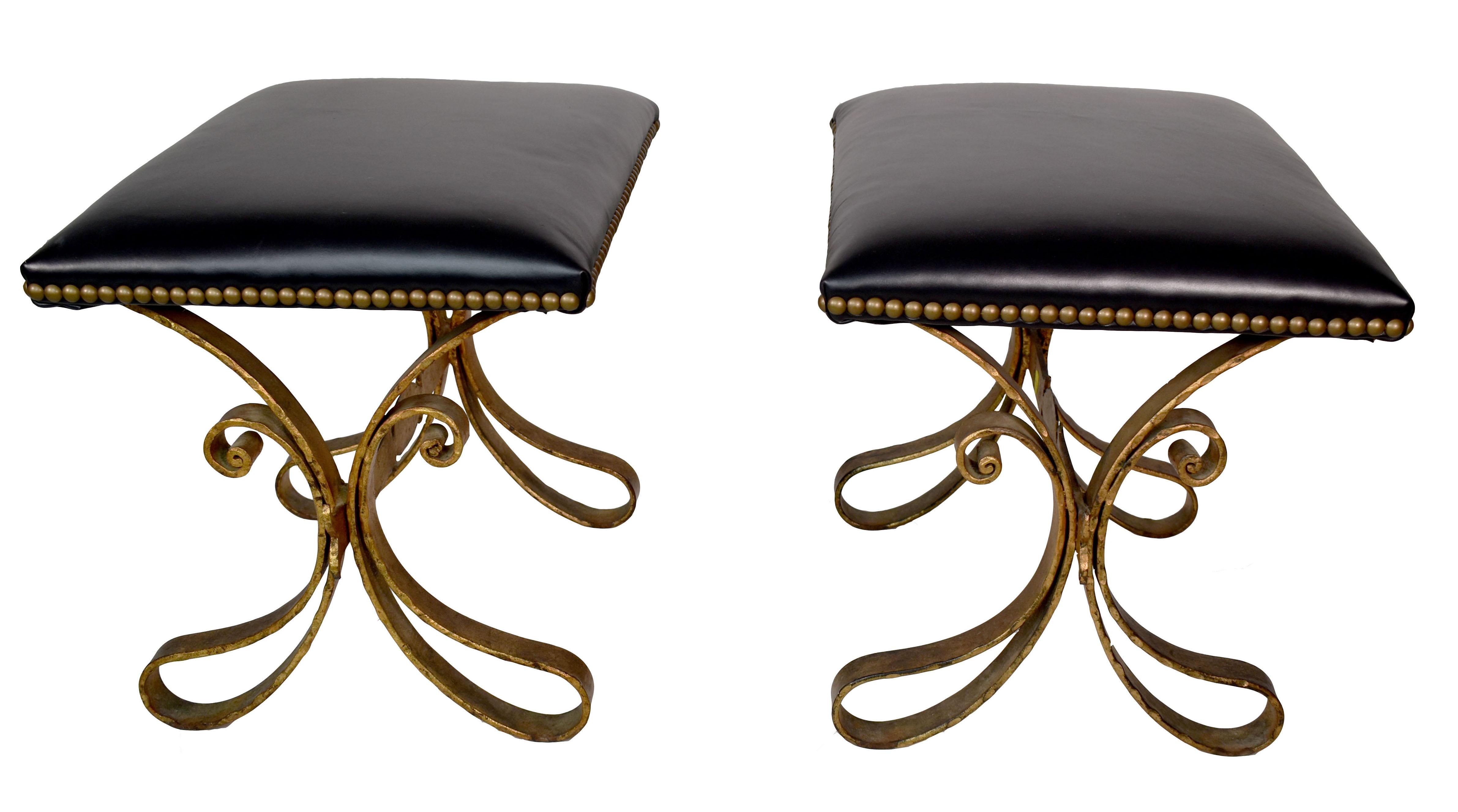 Pair of vintage French gilded, hand-forged iron and upholstered benches or stools. In the style of Gilbert Poillerat. Newly reupholstered in black leather.