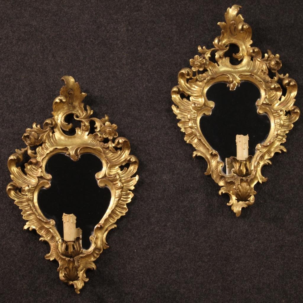 Pair of French mirrors from the mid-20th century. Carved and gilded wooden objects of moderate size and excellent quality. Mirrors equipped with arm in sheet metal electrified with one light each, electrical system to be restored. Furniture of