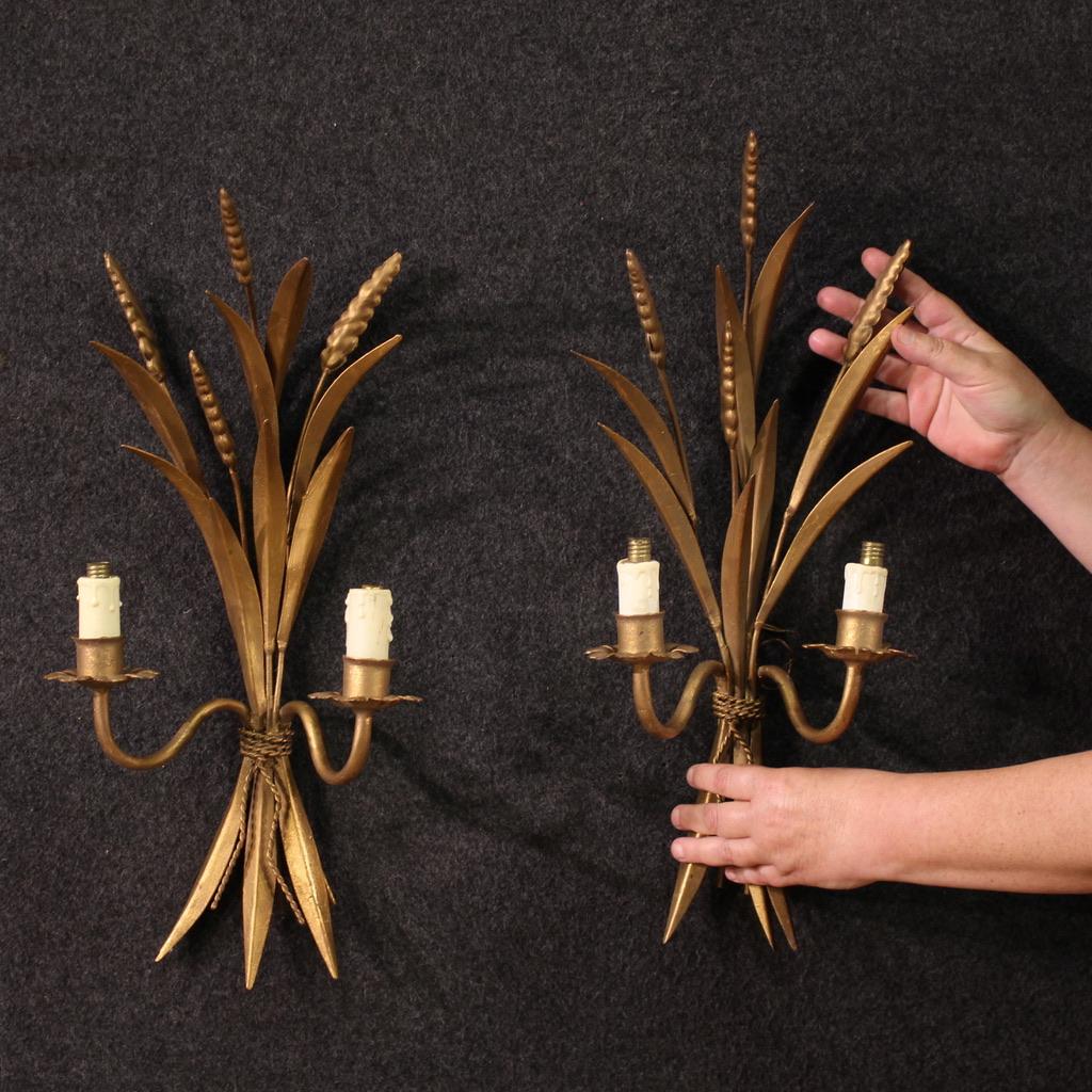 Pair of French wall lights from the 60s/70s. Wrought iron and gilded objects (bronze color) with decorations that recall ears of wheat. Wall lamps equipped with two lights each with electrical system to be overhauled. Objects of beautiful size and