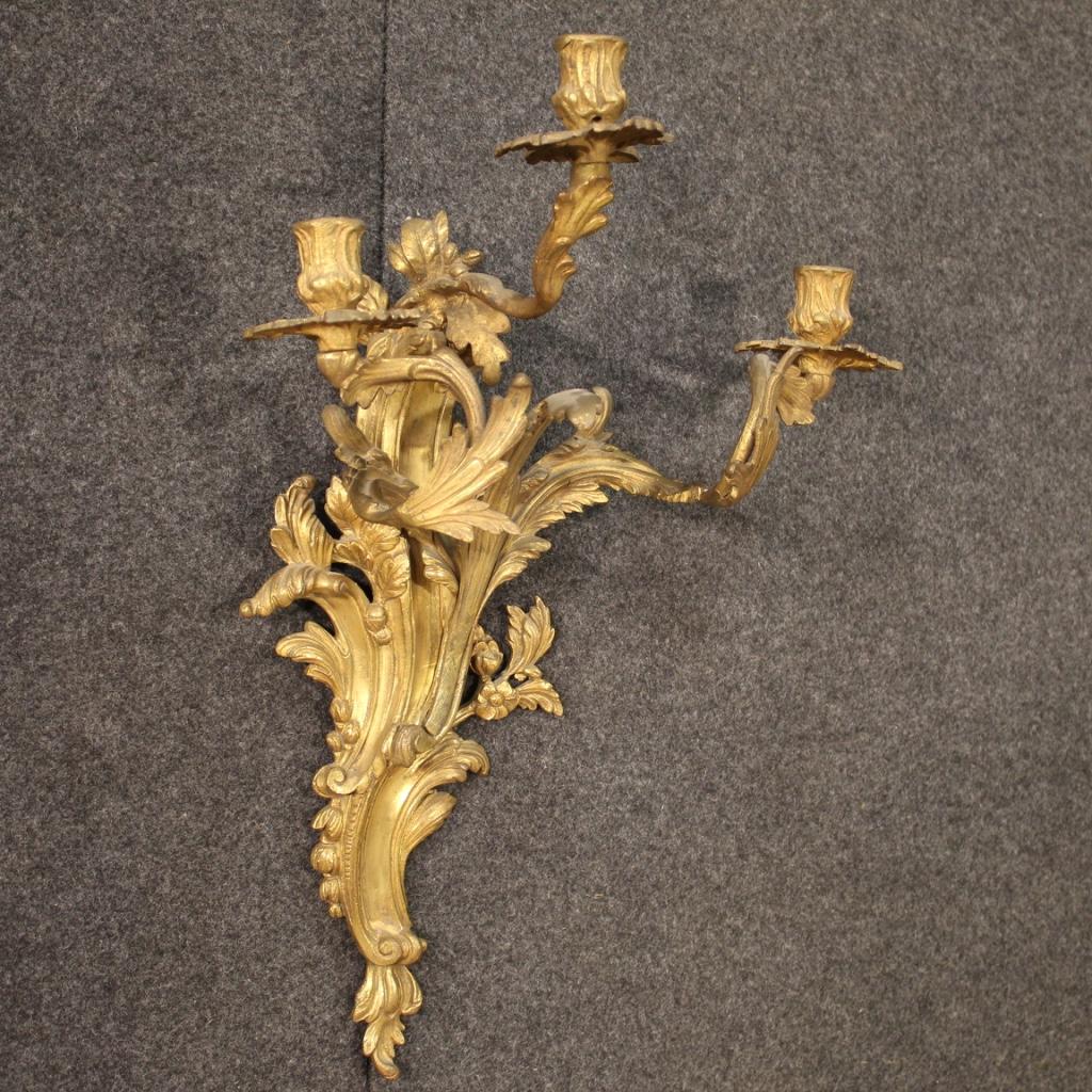 Pair of 20th century French wall lamps. Louis XV style objects in gilded and chiseled bronze of beautiful size and pleasant decor. Wall lights to be fixed to the wall with three arms each, which can be easily placed in different parts of the house.