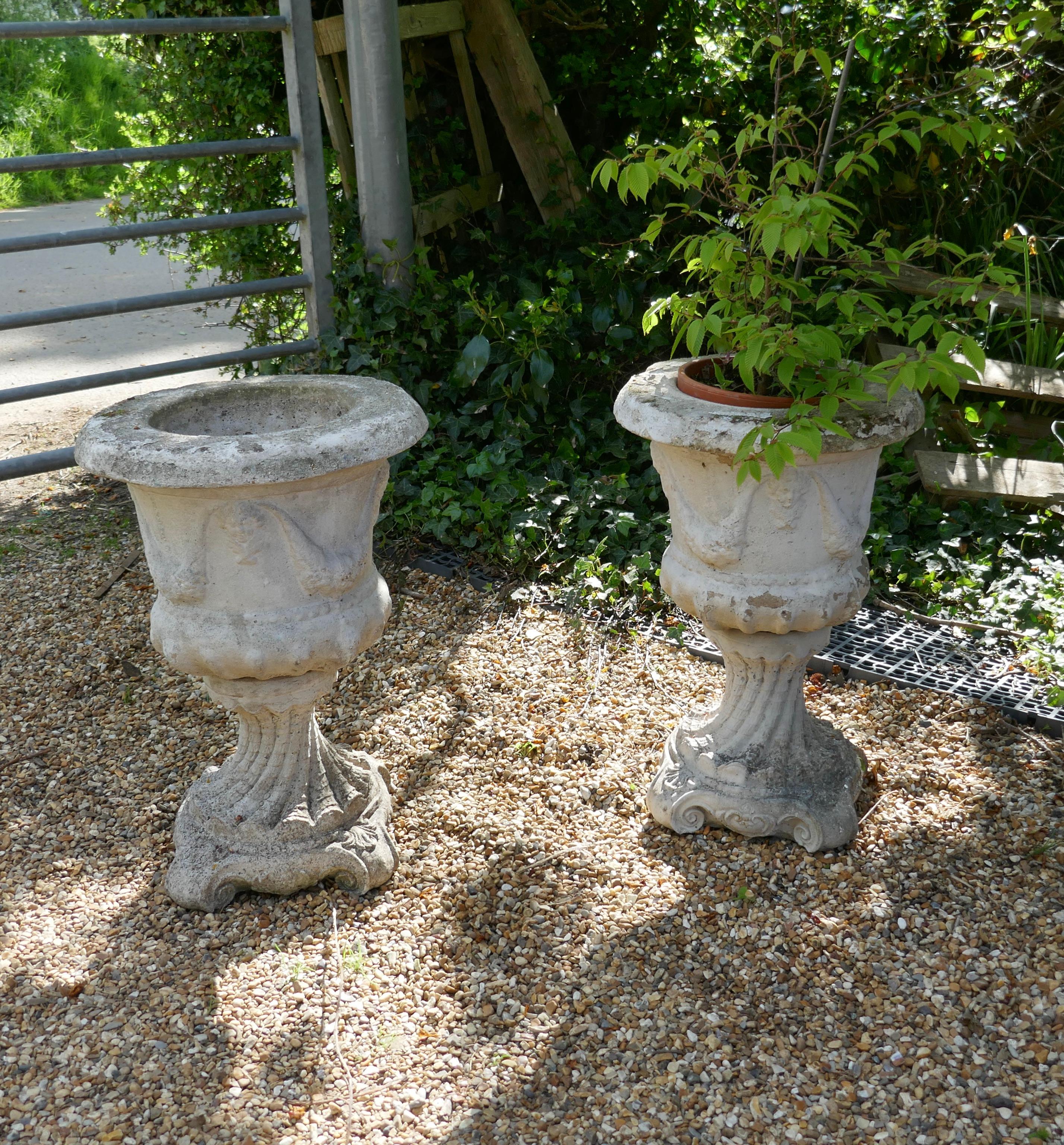 Pair of 20th century green man cast garden planters

A good pair of mid 20th century planters, they are decorated in the Gothic style with swags and faces. They are well weathered and have a drainage hole in the centre, the pots and the bases come