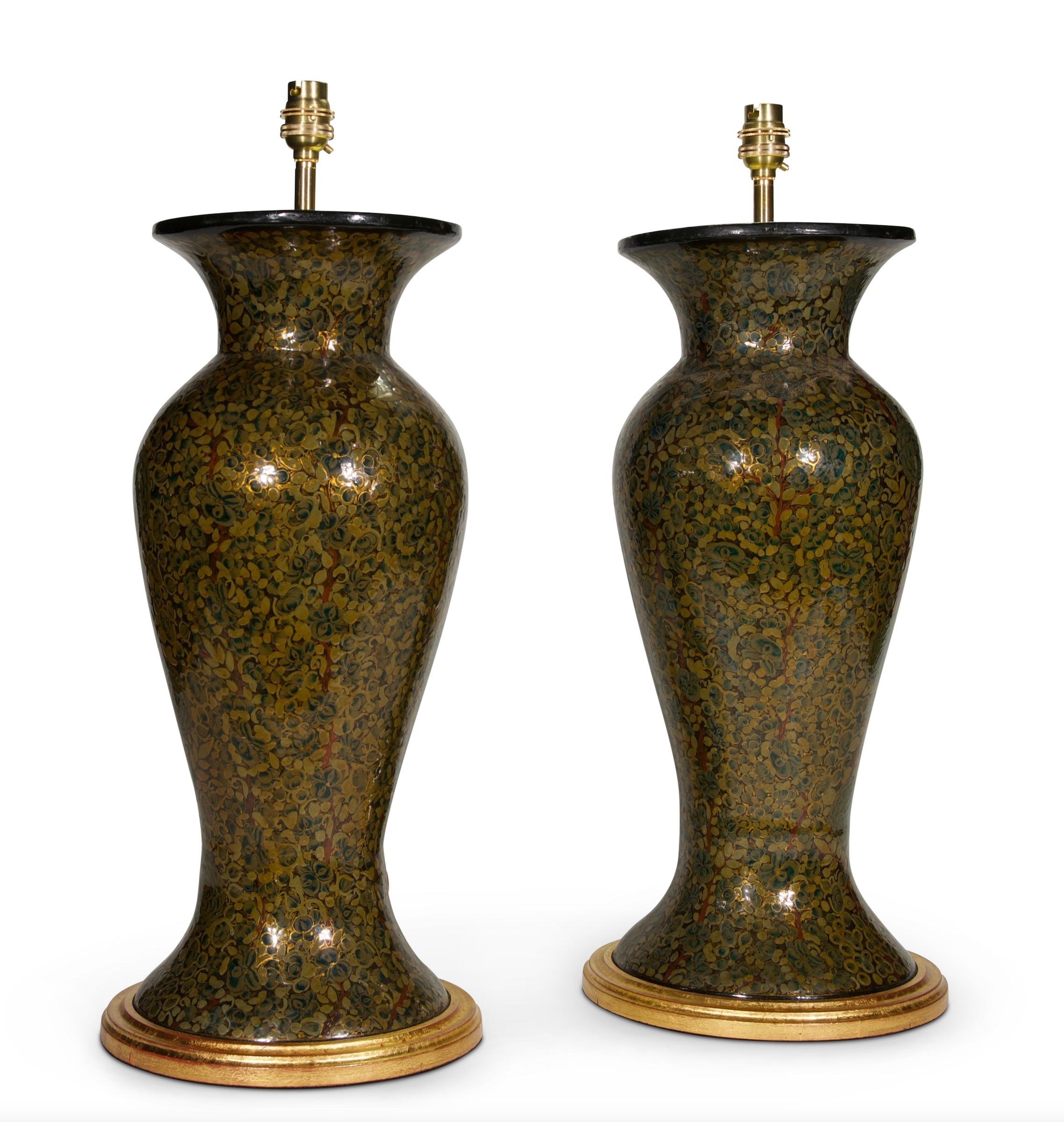 A fine pair of 20th century Kashmiri lacquer baluster vases, decorated thoughout with foliate motifs in tones of green with gilded highlights, now mounted as lamps with hand gilded turned bases.

Measures: height of vass: 18 1/4 in (46.5 cm)