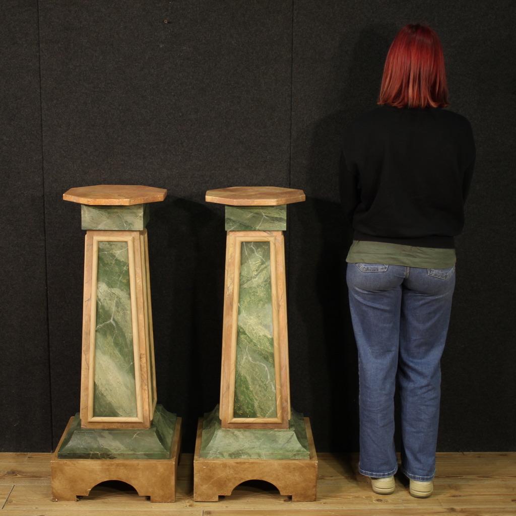Pair of Italian columns from the second half of the 20th century. Carved wood and lacquered faux marble furniture of fabulous decoration. These wooden columns offer excellent stability and solidity, with a well-sized and functional octagonal top,