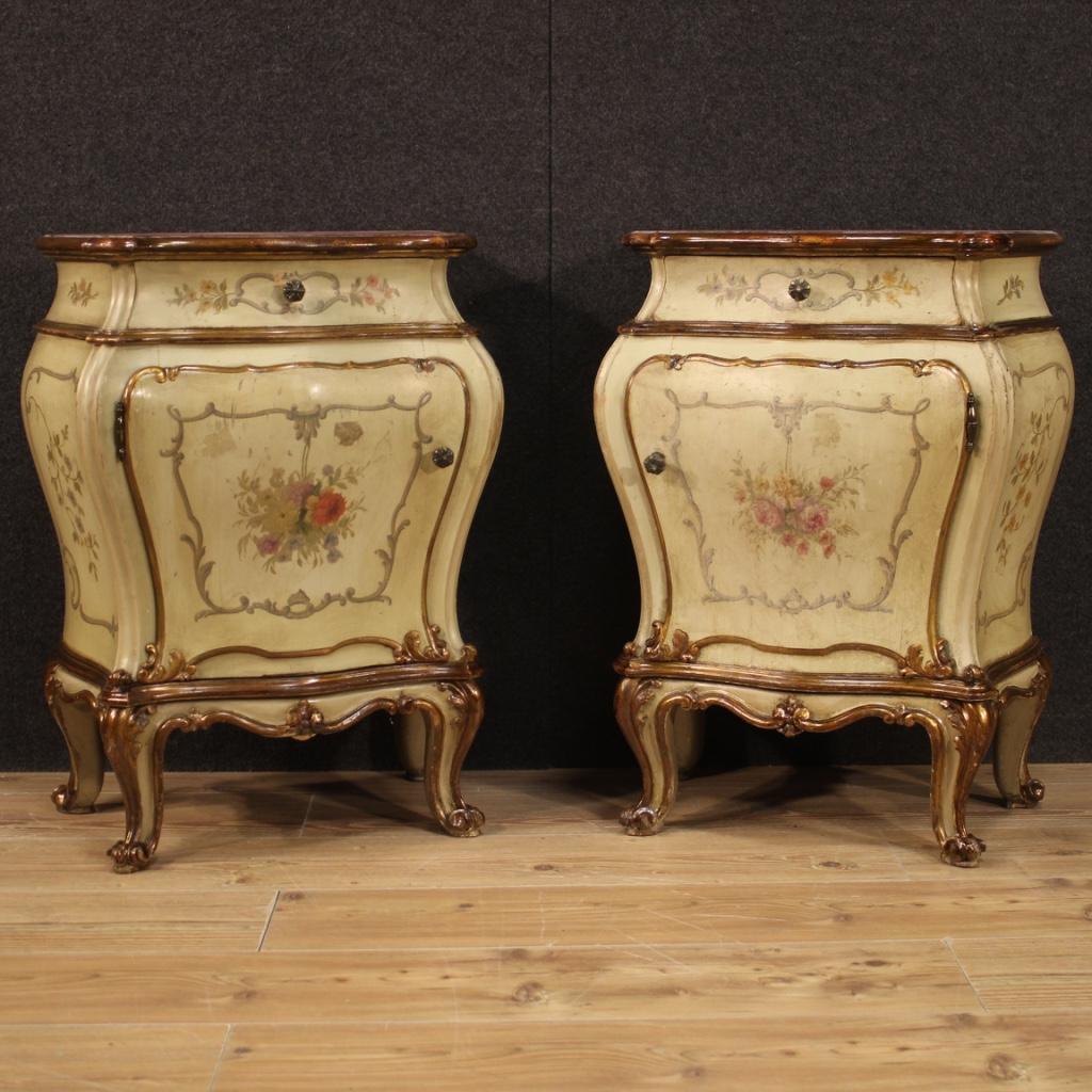 Pair of Venetian bedside tables from the mid-20th century. Furniture in carved, lacquered, gilded (bronze tinted) and hand painted wood of very pleasant floral decorations. Wavy and rounded night stands equipped with a door and a front drawer of