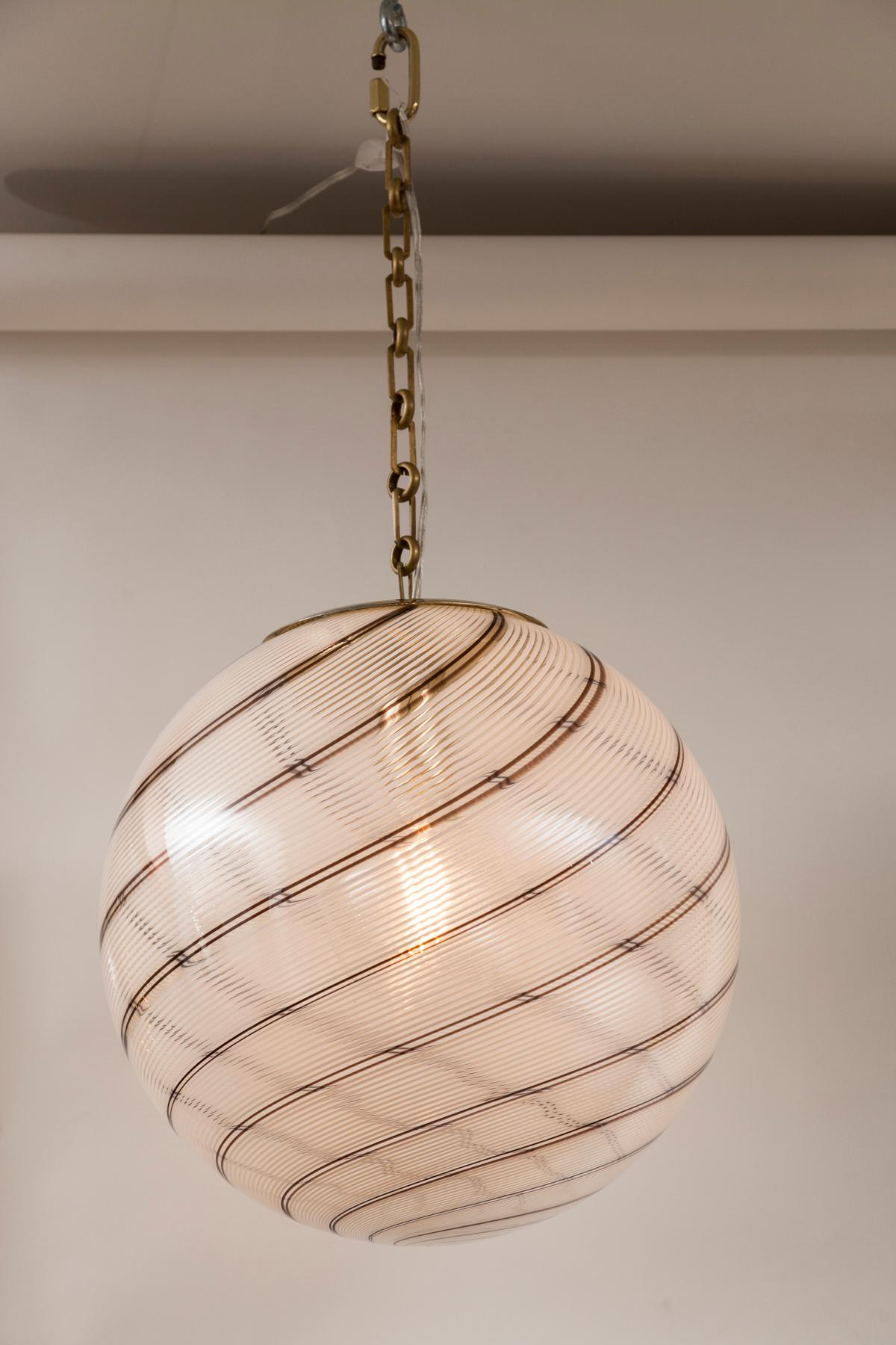  Lovely pair of  large clear blown glass globe shaped globes with a swirl of filigrini tobacco and white.
Recently re-electrified with new medium base E26 socket and made install ready with beautiful brass chain and canopy of your choice.